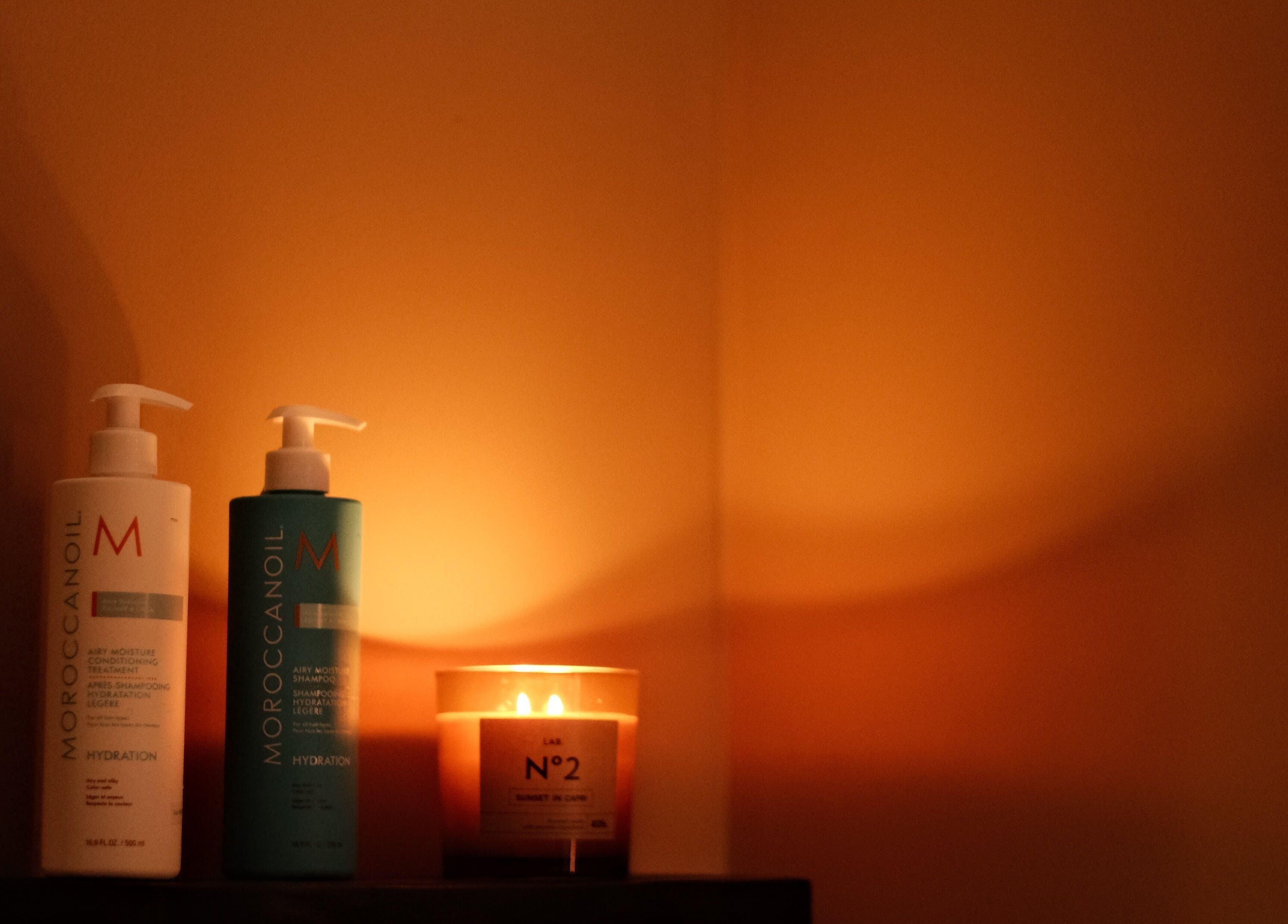 Warm candlelight illuminates hair products at Recharged SPA, Đà Nẵng, Đà Nẵng, VN for a calming ambiance.