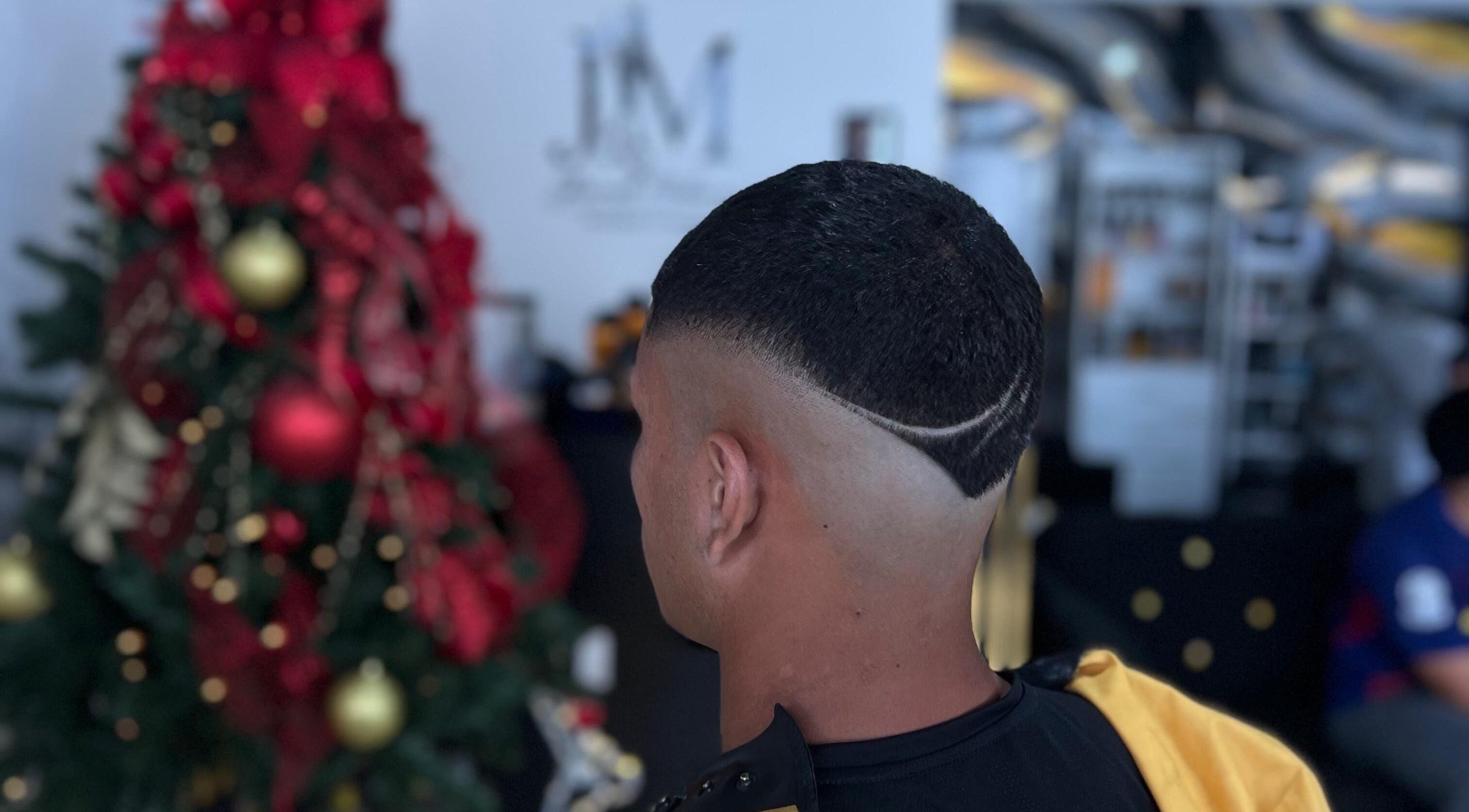 Intricate fade haircut at Hache Barber, Panamá, Provincia De Panamá, PA, near a festive Christmas tree.