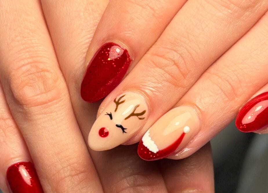 Diseño navideño de uñas en Beii Nails ✨💅🏼, Comunidad De Madrid, ES. Uñas rojas con reno y gorro navideño.