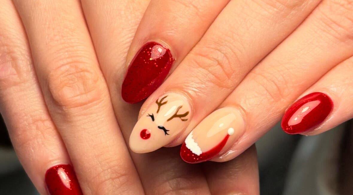 Diseño navideño de uñas en Beii Nails ✨💅🏼, Comunidad De Madrid, ES. Uñas rojas con reno y gorro navideño.