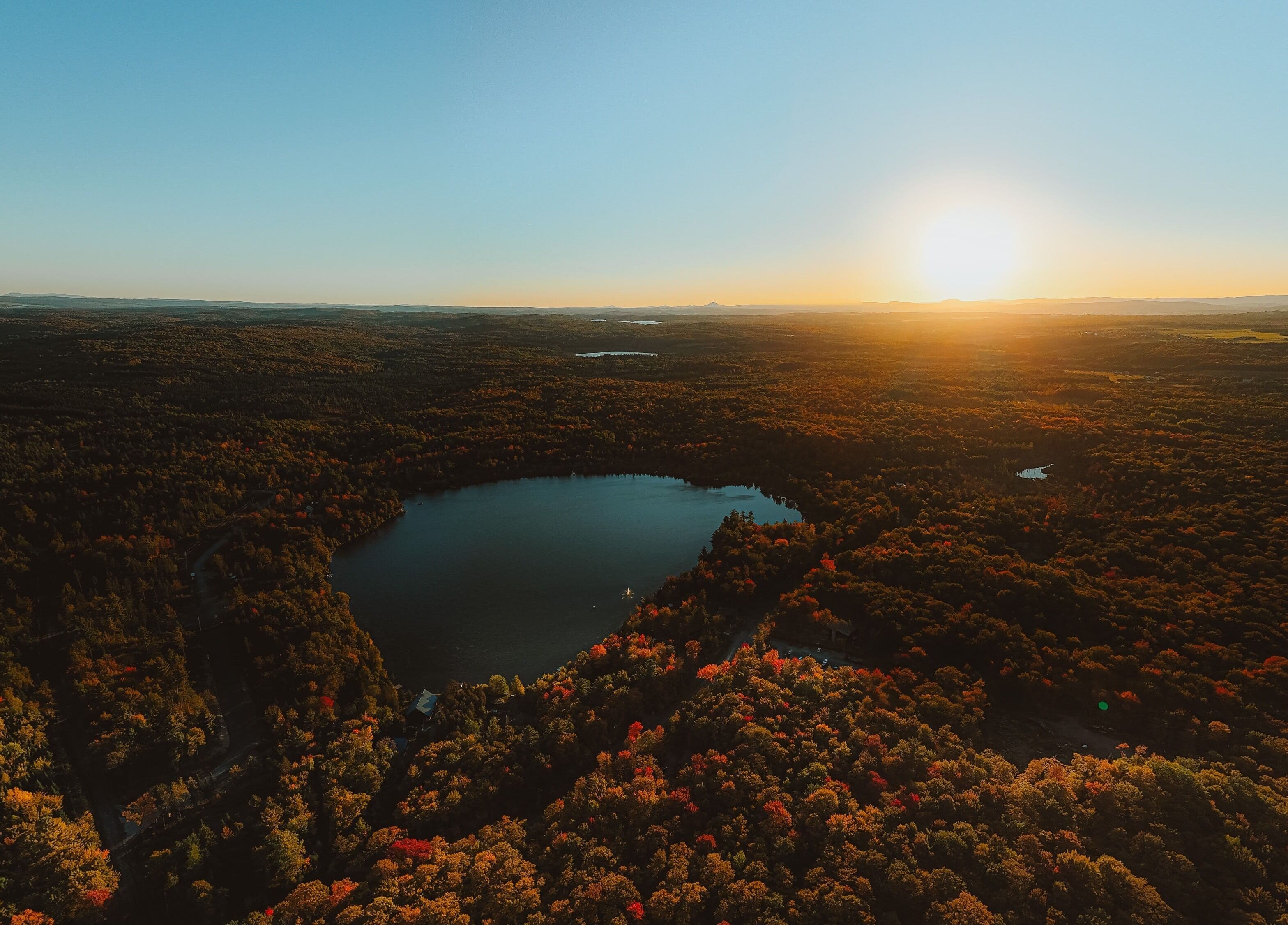 Vue aérienne du lac près de Sartiga Spa sur le Lac à Saint-alfred, Québec, CA, sous un coucher de soleil vibrant.