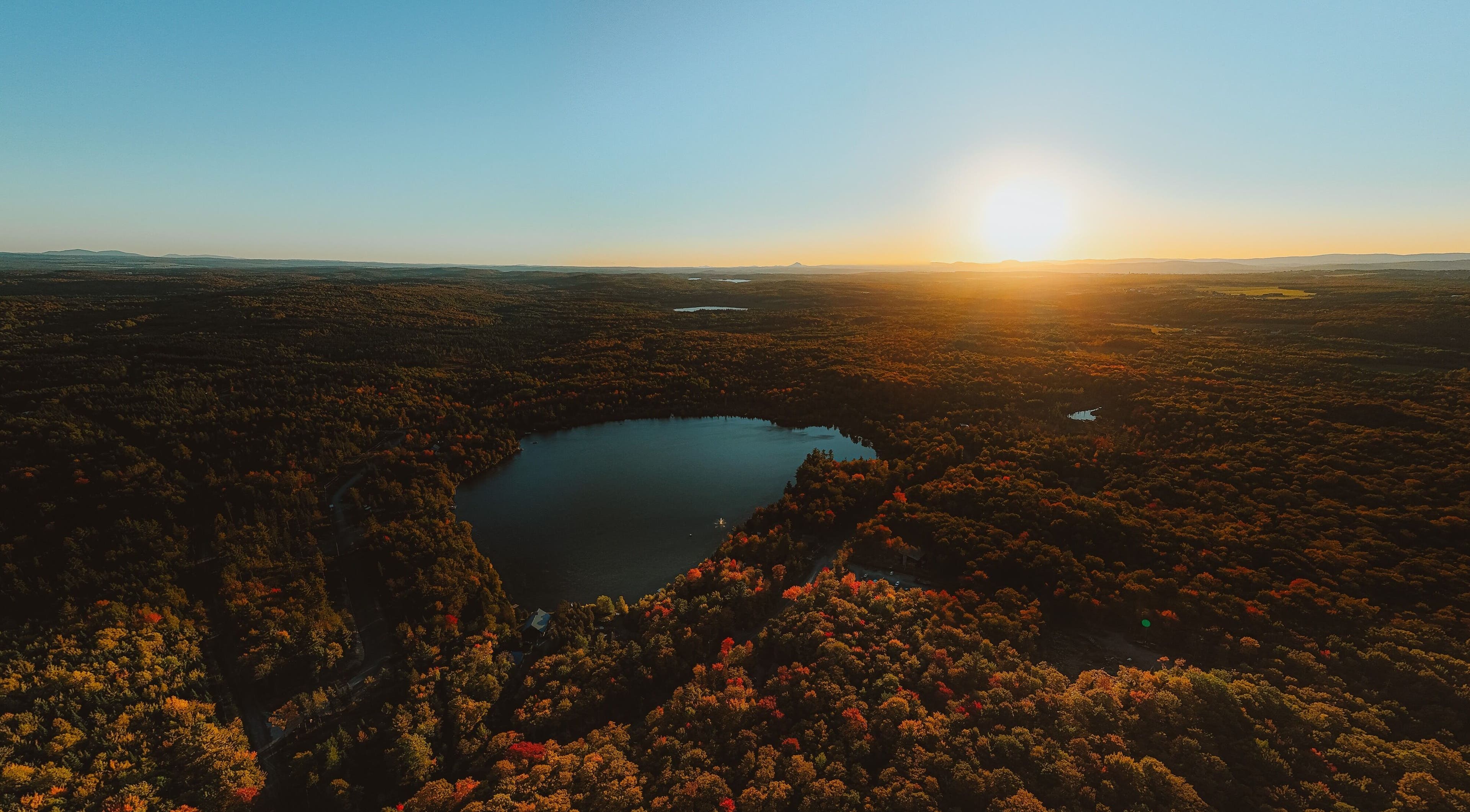 Vue aérienne du lac près de Sartiga Spa sur le Lac à Saint-alfred, Québec, CA, sous un coucher de soleil vibrant.