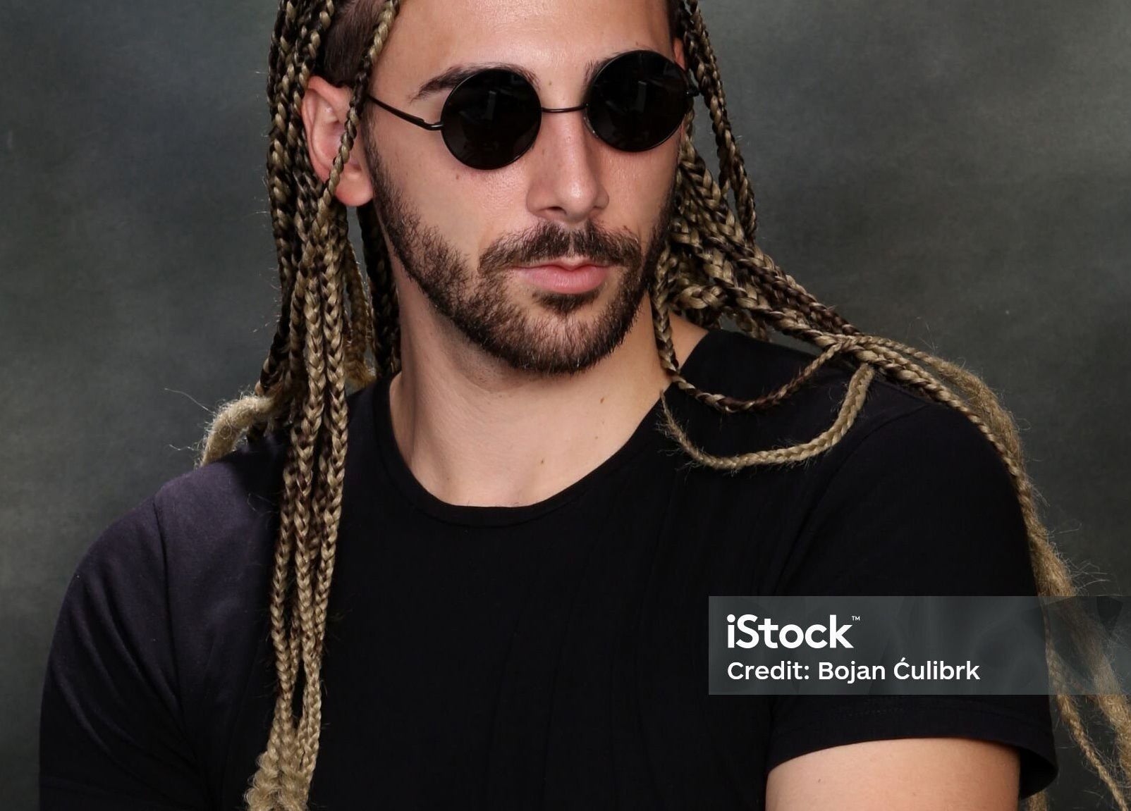 Man with braided hairstyle and sunglasses featured at Dan hair style, Birmingham, England, GB.
