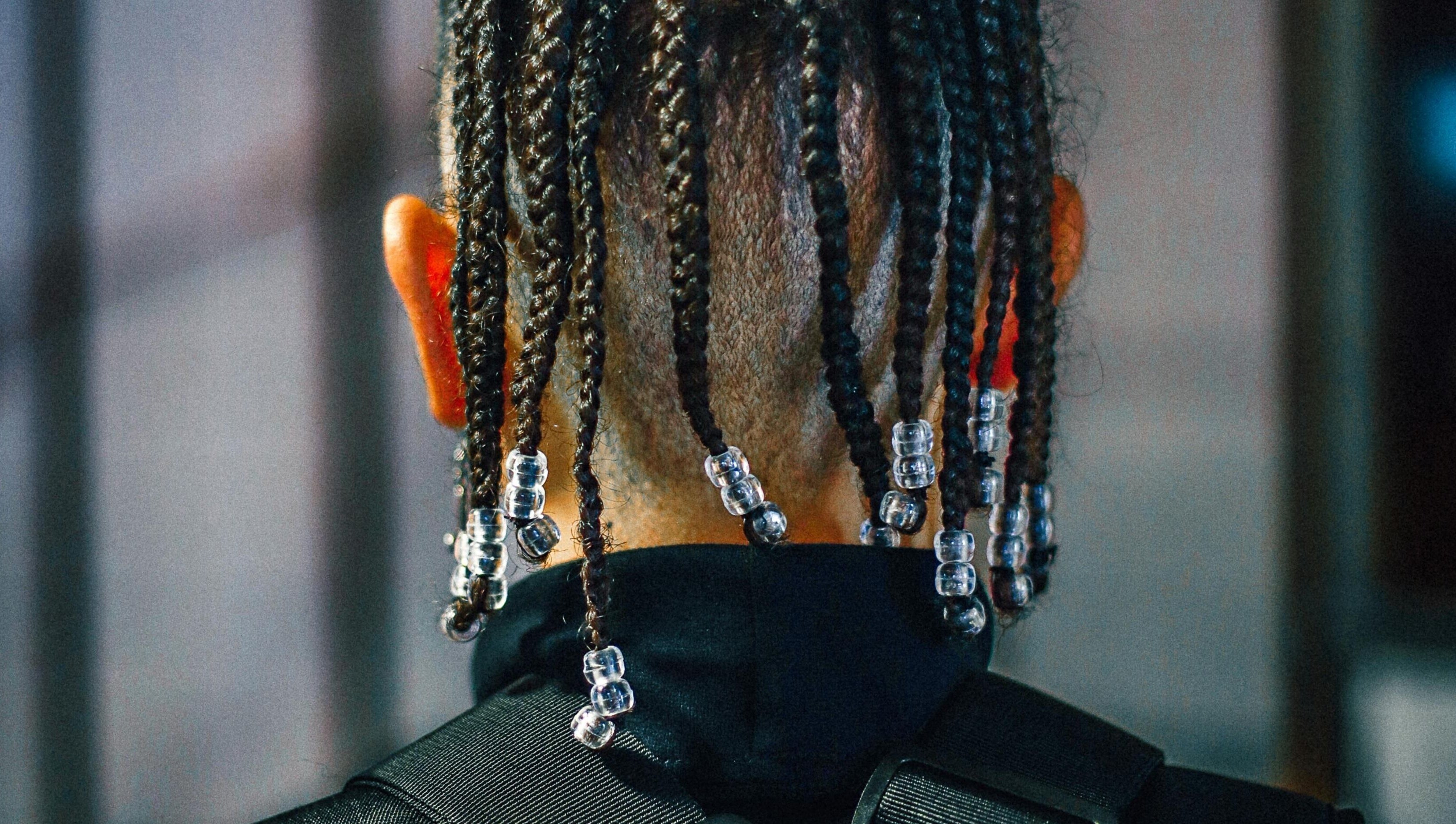 Back view of beaded braids hairstyle at Dan Hair Style in Birmingham, England, GB.