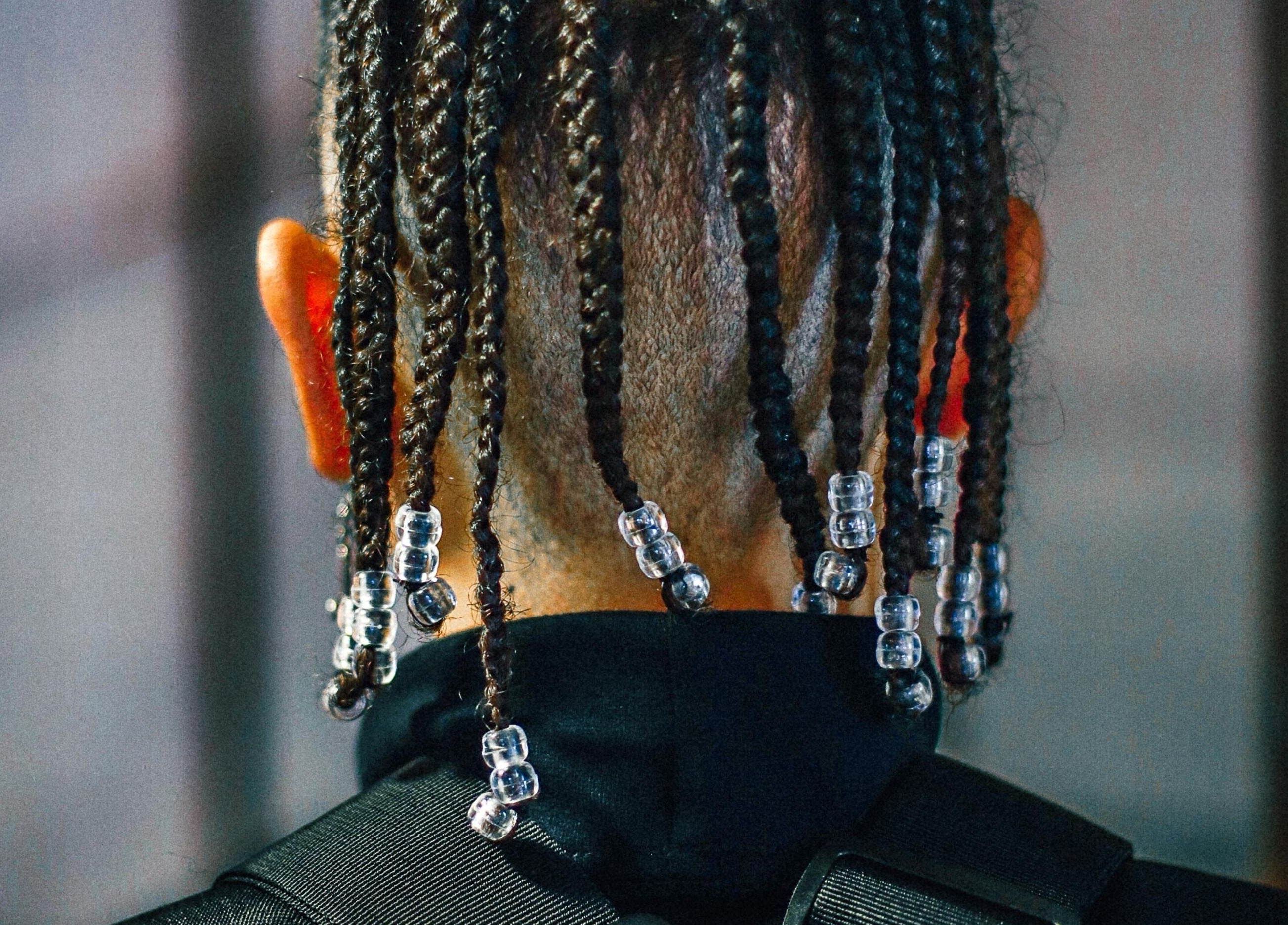 Back view of beaded braids hairstyle at Dan Hair Style in Birmingham, England, GB.