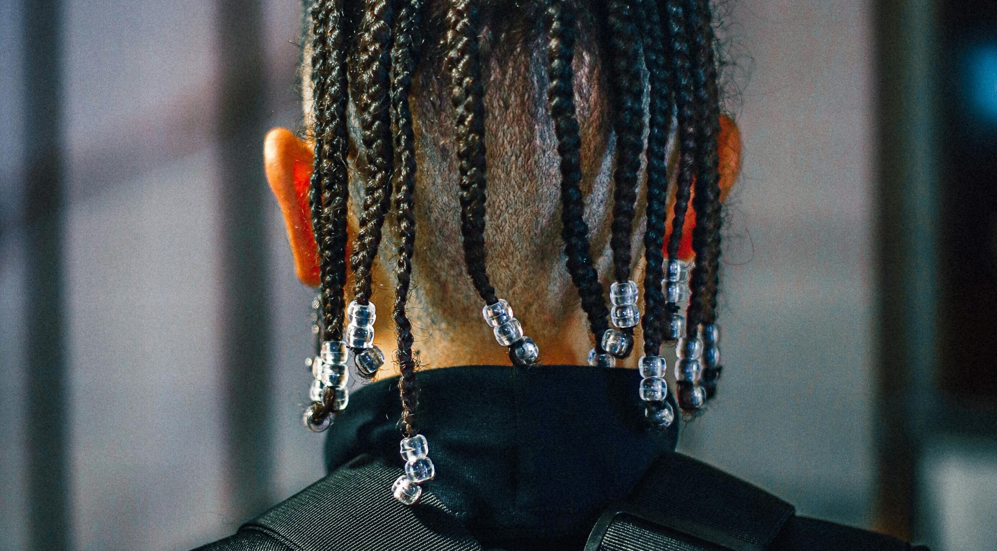 Back view of beaded braids hairstyle at Dan Hair Style in Birmingham, England, GB.