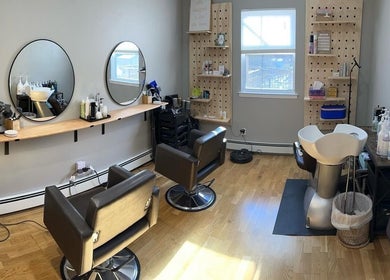 Modern salon interior at NME Hairstylist in Islip Terrace, New York, US, featuring styling chairs and mirrors.