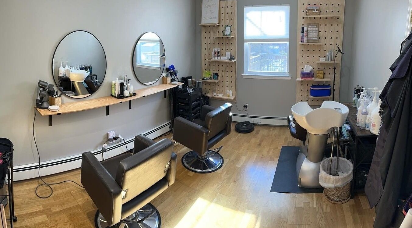 Modern salon interior at NME Hairstylist in Islip Terrace, New York, US, featuring styling chairs and mirrors.