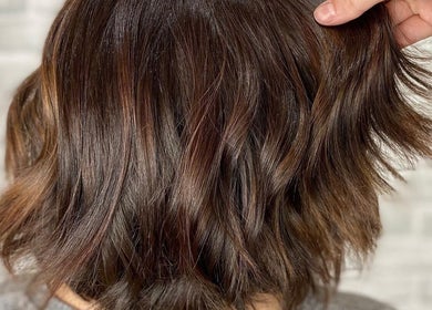 Styled brunette hair shines at NME Hairstylist, Islip Terrace, New York, US, showcasing expert haircare.