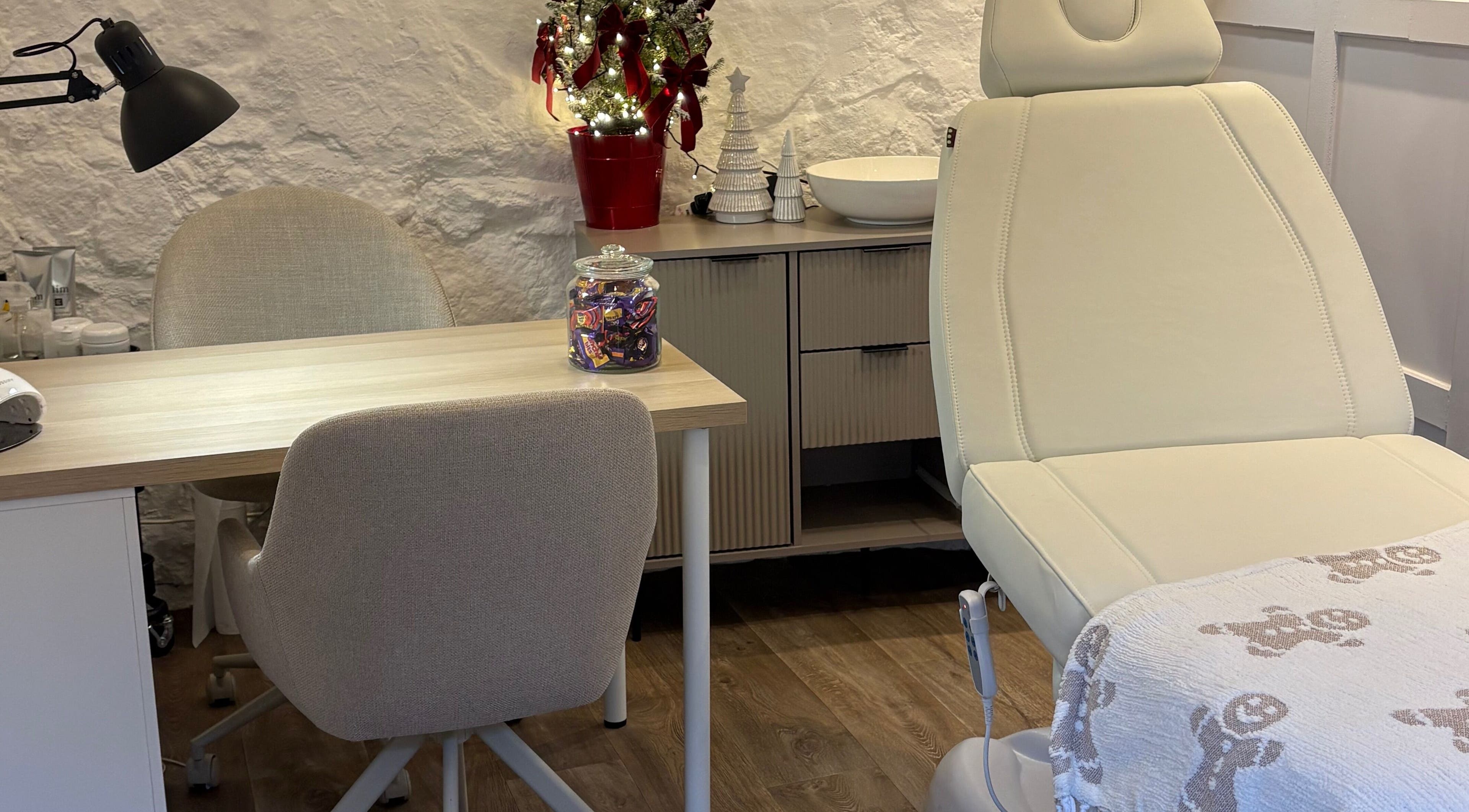 A cozy treatment room at Made Creative Beauty, Rothley, England, GB with a chair and festive decor.