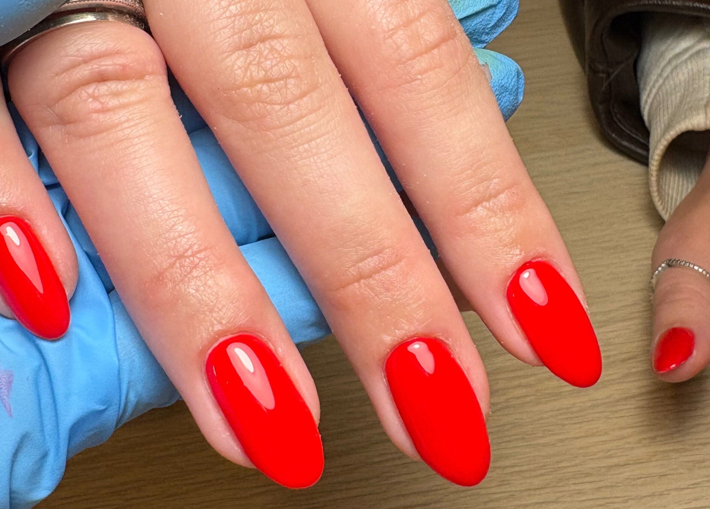 Vibrant red nails manicured at Made Creative Beauty in Rothley, England, GB. Showcasing expert nail artistry.