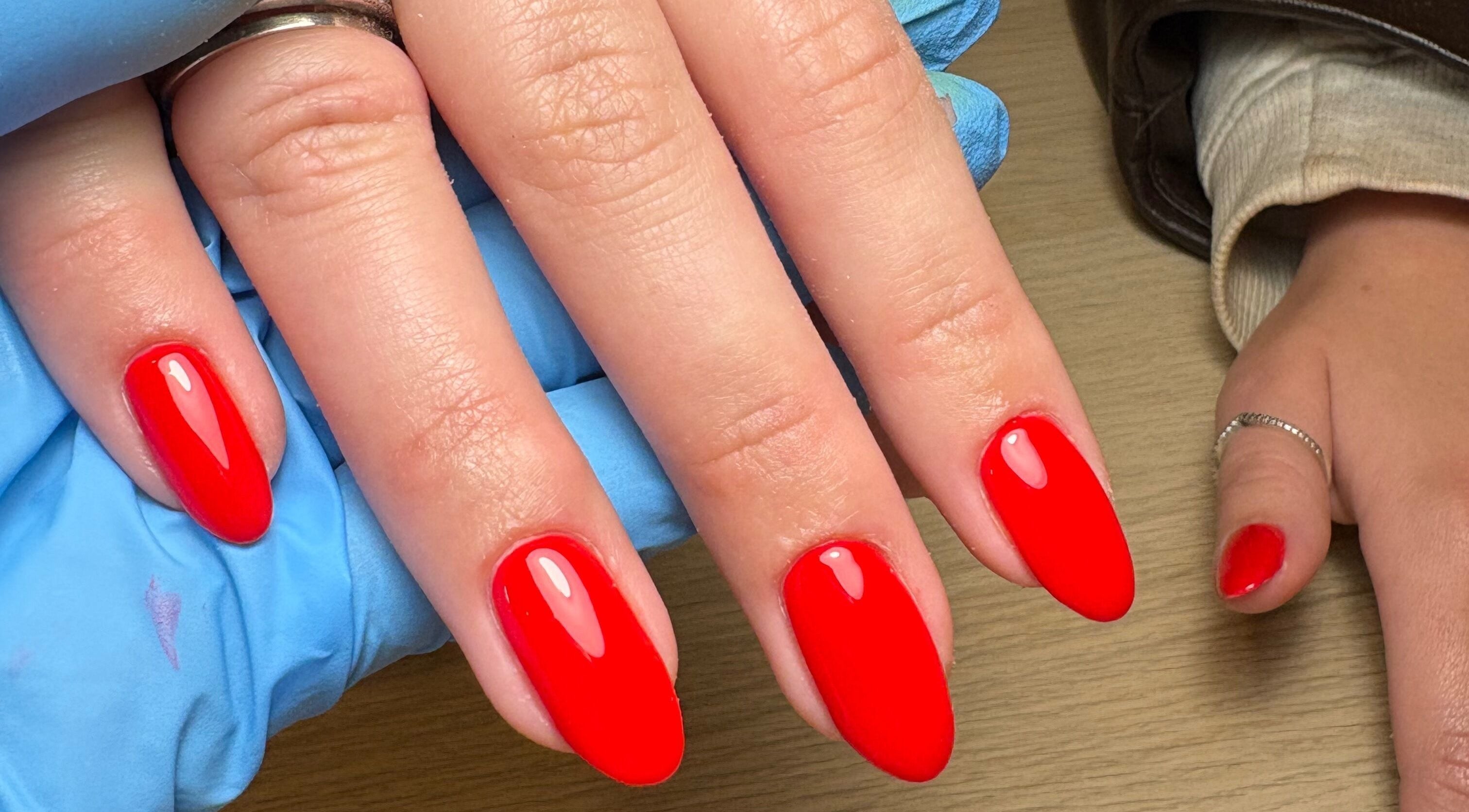 Vibrant red nails manicured at Made Creative Beauty in Rothley, England, GB. Showcasing expert nail artistry.