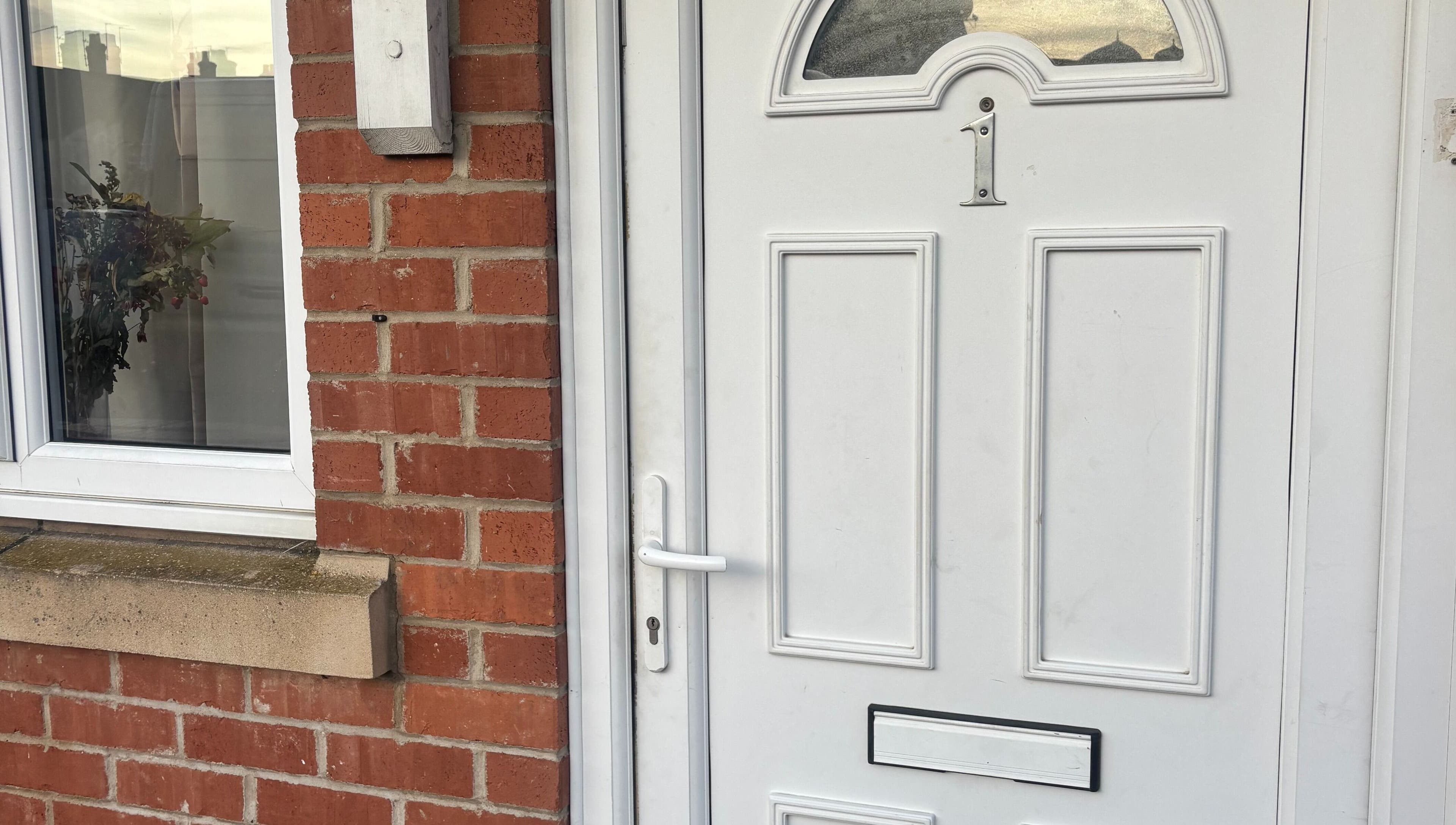 Front door of TGLAMHAUS, a beauty and wellness venue in Peterborough, England, GB, showcasing elegant brickwork.