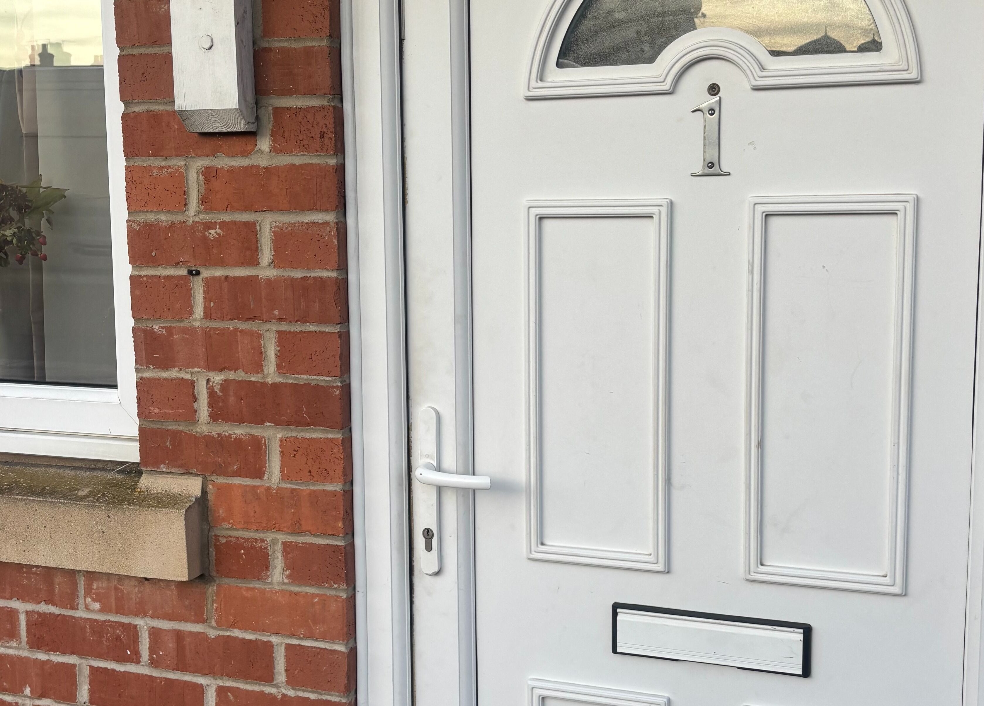 Front door of TGLAMHAUS, a beauty and wellness venue in Peterborough, England, GB, showcasing elegant brickwork.