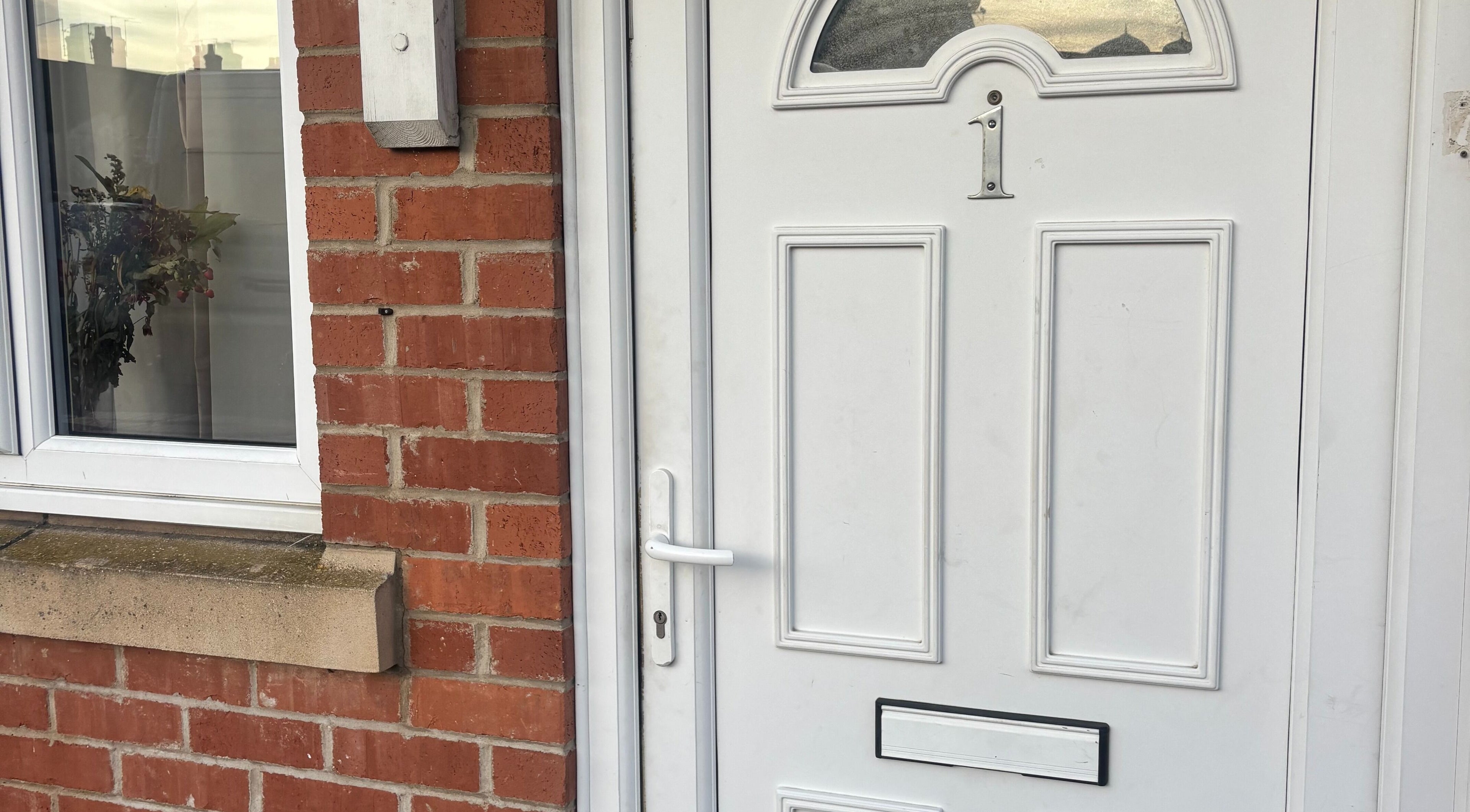 Front door of TGLAMHAUS, a beauty and wellness venue in Peterborough, England, GB, showcasing elegant brickwork.