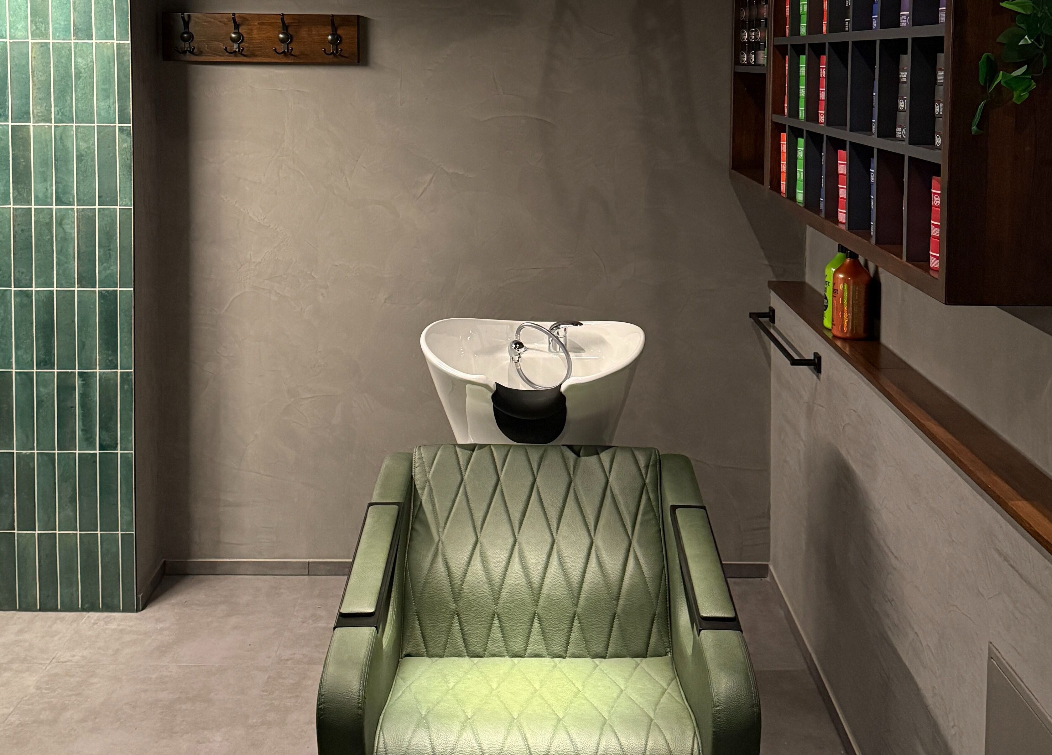 Moderner Salonbereich bei Nishan Coiffeursalon, Walenstadt, Sankt Gallen, CH mit grünem Stuhl und Waschtisch.