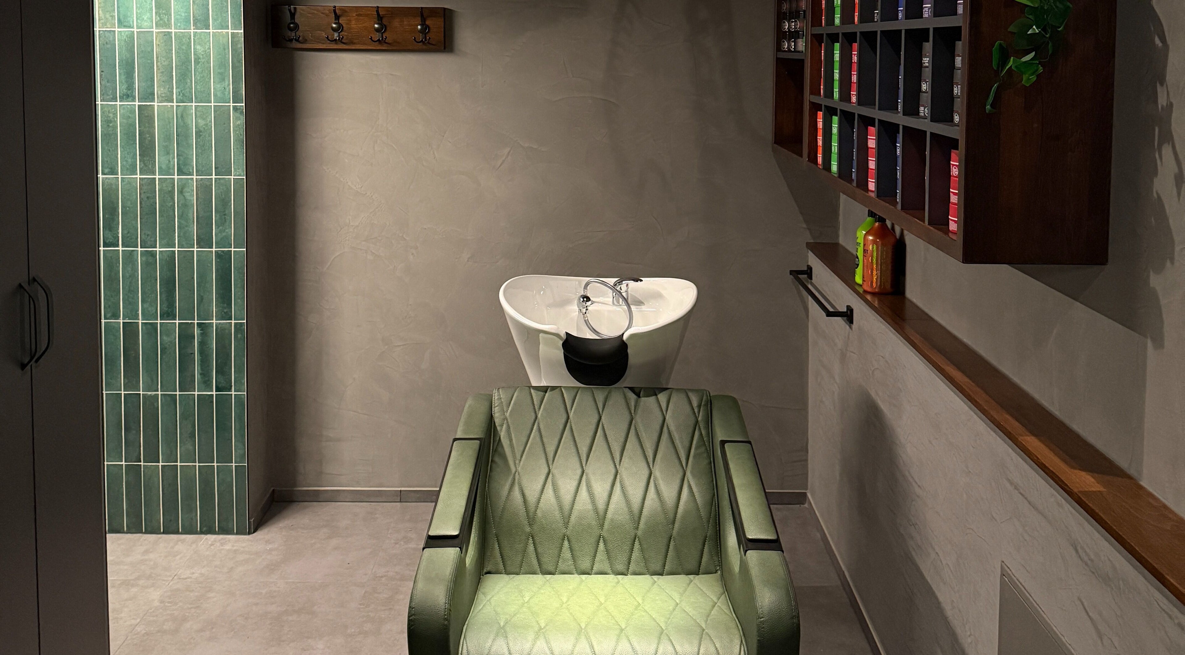 Moderner Salonbereich bei Nishan Coiffeursalon, Walenstadt, Sankt Gallen, CH mit grünem Stuhl und Waschtisch.