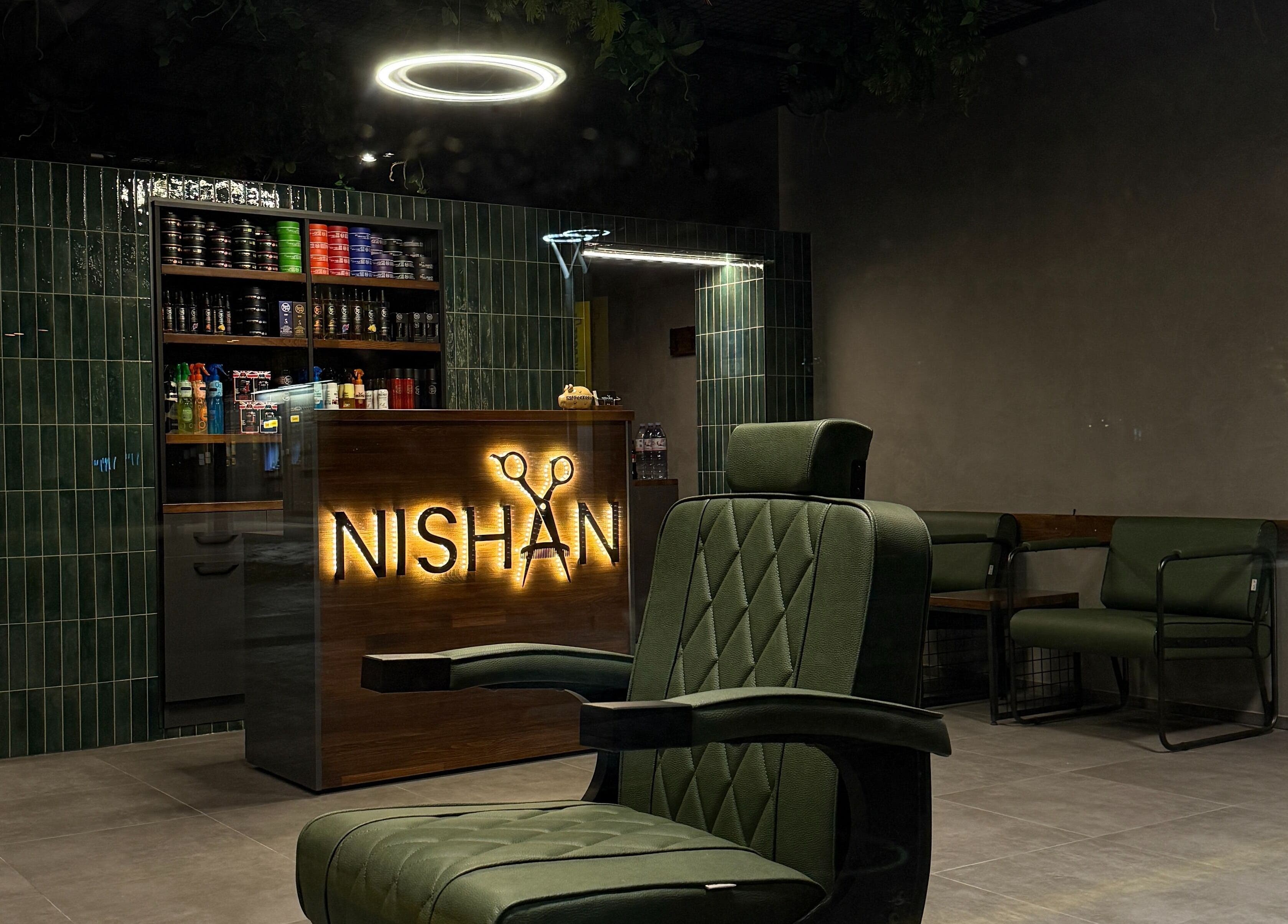 Innenansicht von Nishan Coiffeursalon in Walenstadt, Sankt Gallen, CH mit modernem Stuhl und beleuchtetem Tresen.