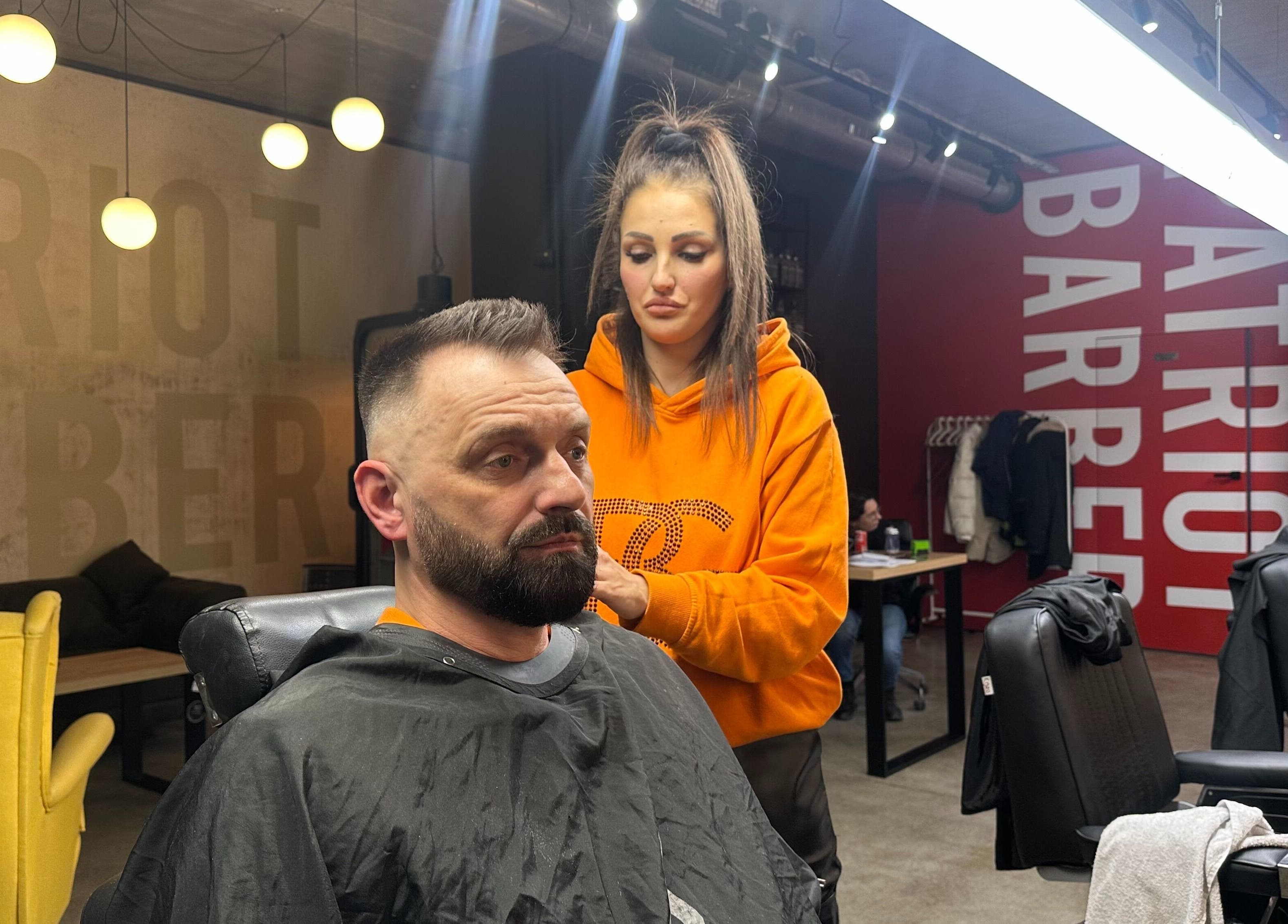 Stylowy salon Patriot Barberletnica w Gdańsku, Województwo Pomorskie, PL. Stylistka wykonuje strzyżenie.