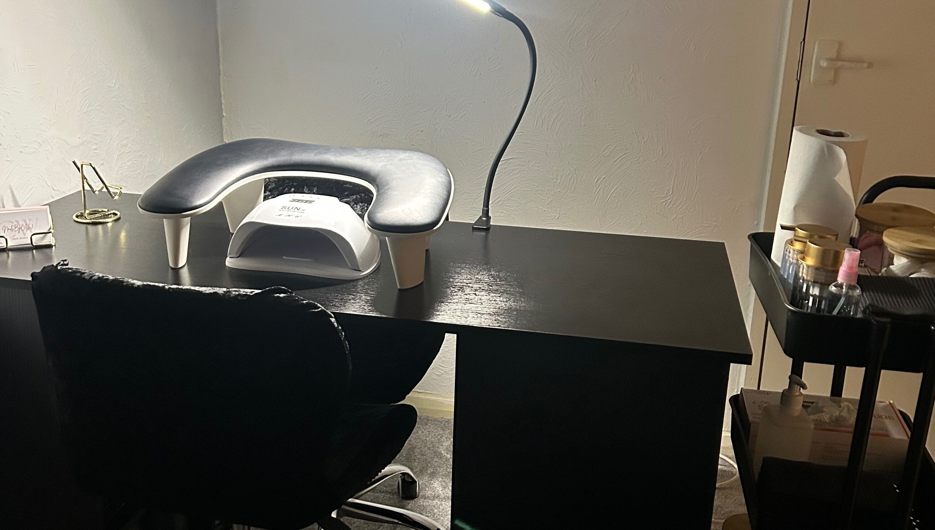 Modern nail station at Nailsbyci in Stoke-on-Trent, England, with a lamp and supplies for manicure.