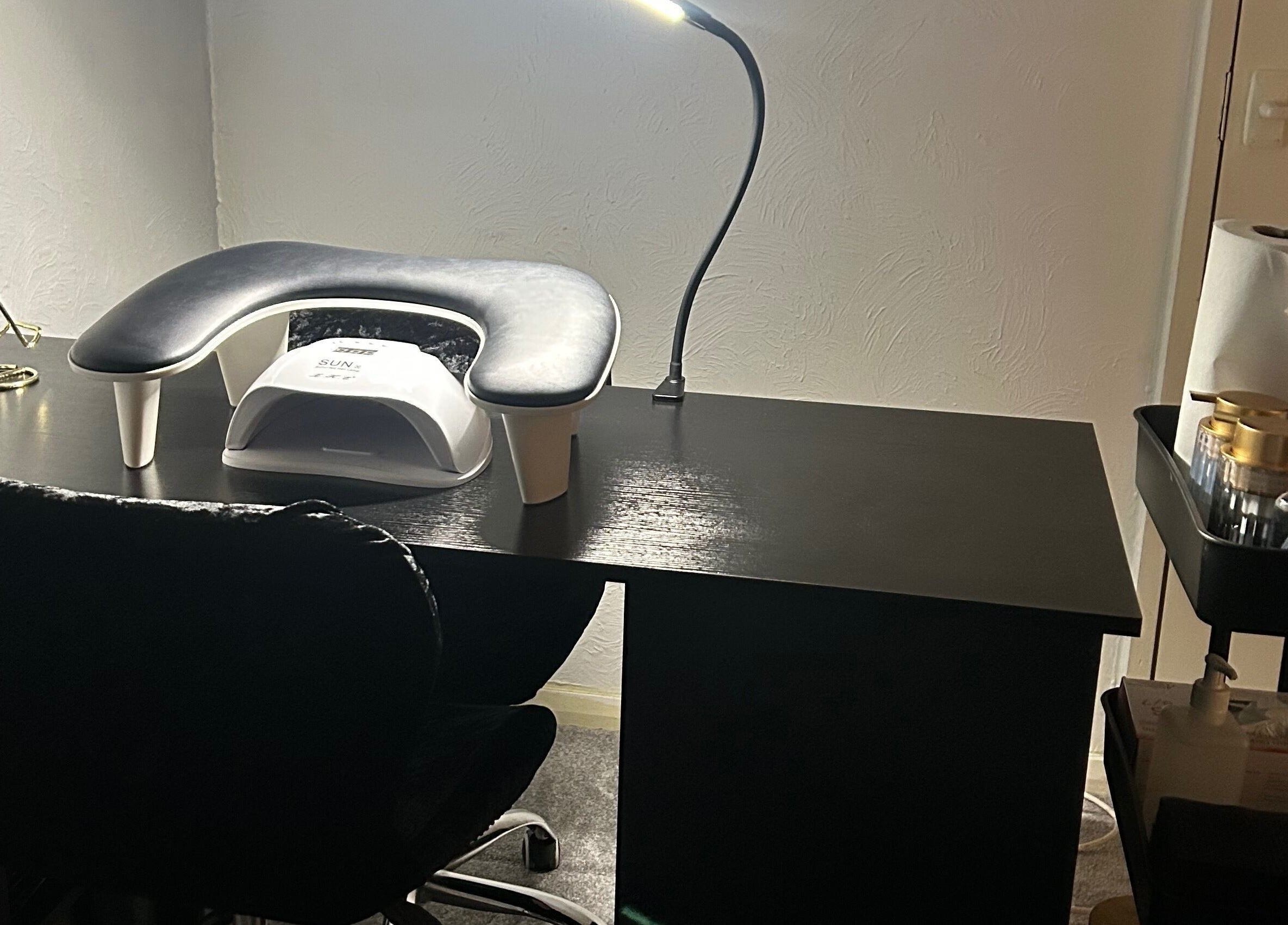 Modern nail station at Nailsbyci in Stoke-on-Trent, England, with a lamp and supplies for manicure.