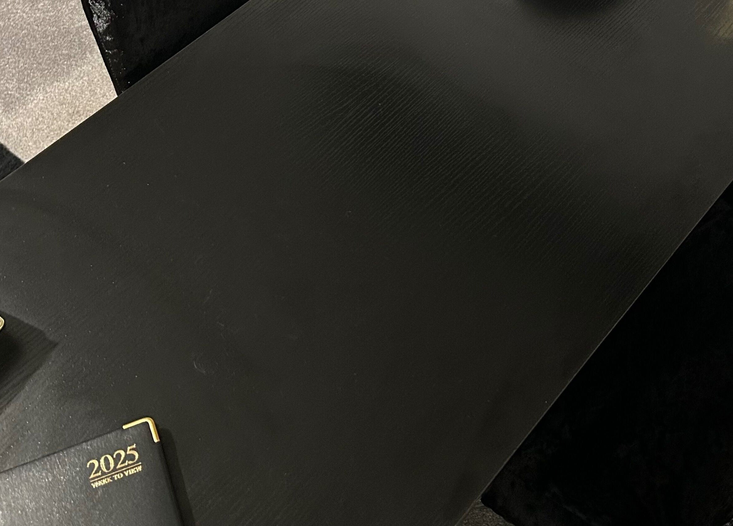 Sophisticated black table at Nailsbyci, Stoke-on-Trent, England, GB, with a planner and cardholder.