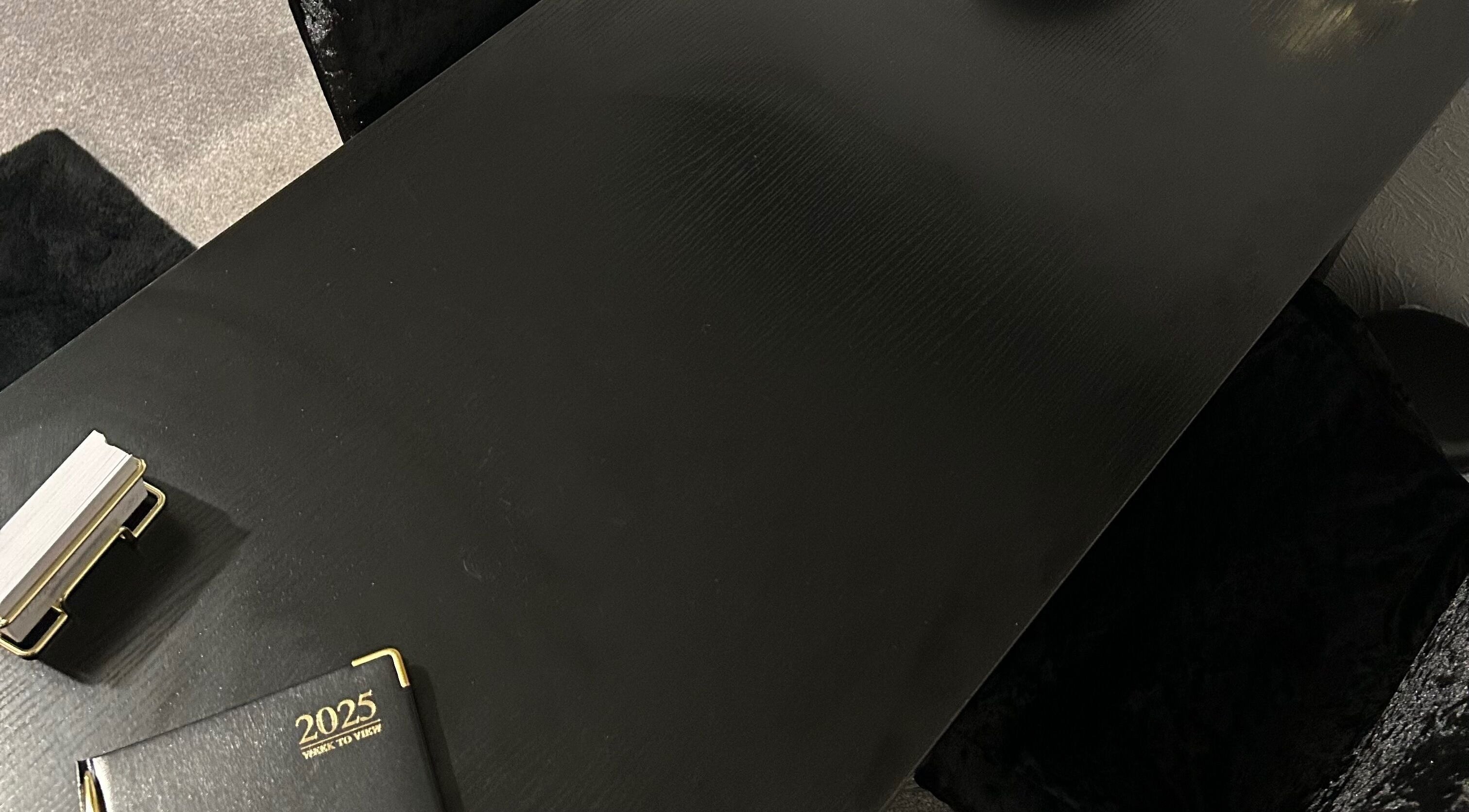 Sophisticated black table at Nailsbyci, Stoke-on-Trent, England, GB, with a planner and cardholder.