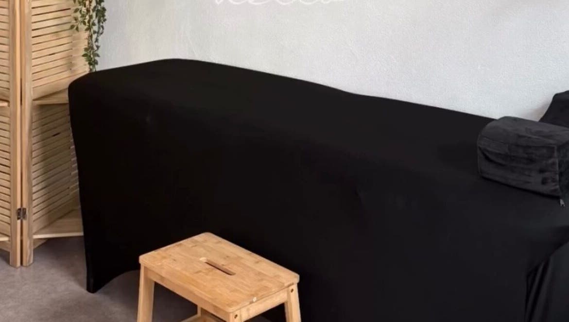 Salle de massage élégante à Le Cocon D’Ema, Laneuveville-lès-lorquin, Grand Est, FR, avec table noire.