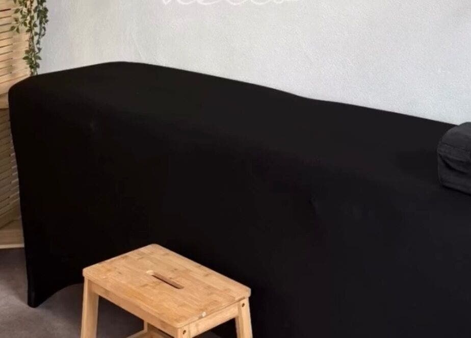 Salle de massage élégante à Le Cocon D’Ema, Laneuveville-lès-lorquin, Grand Est, FR, avec table noire.