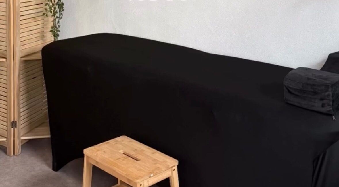 Salle de massage élégante à Le Cocon D’Ema, Laneuveville-lès-lorquin, Grand Est, FR, avec table noire.