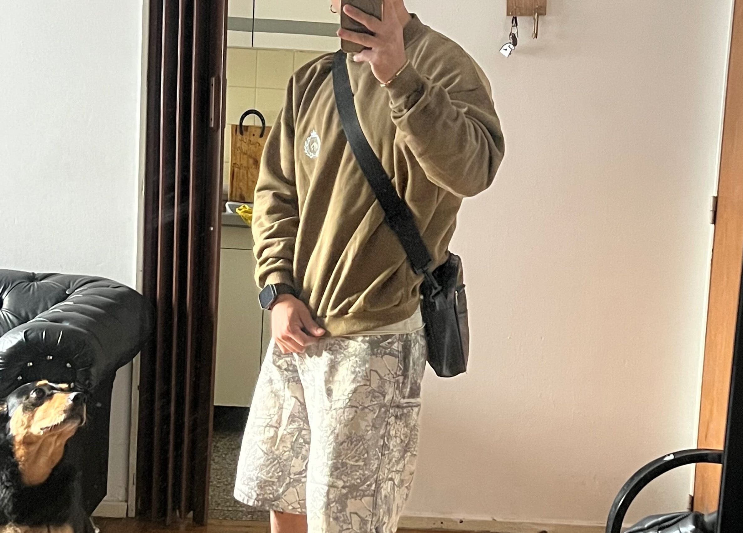 A person in casual attire with a dog in front of a mirror at Lucas Lezcano, Buenos Aires, Ciudad Autónoma De Buenos Aires, AR.