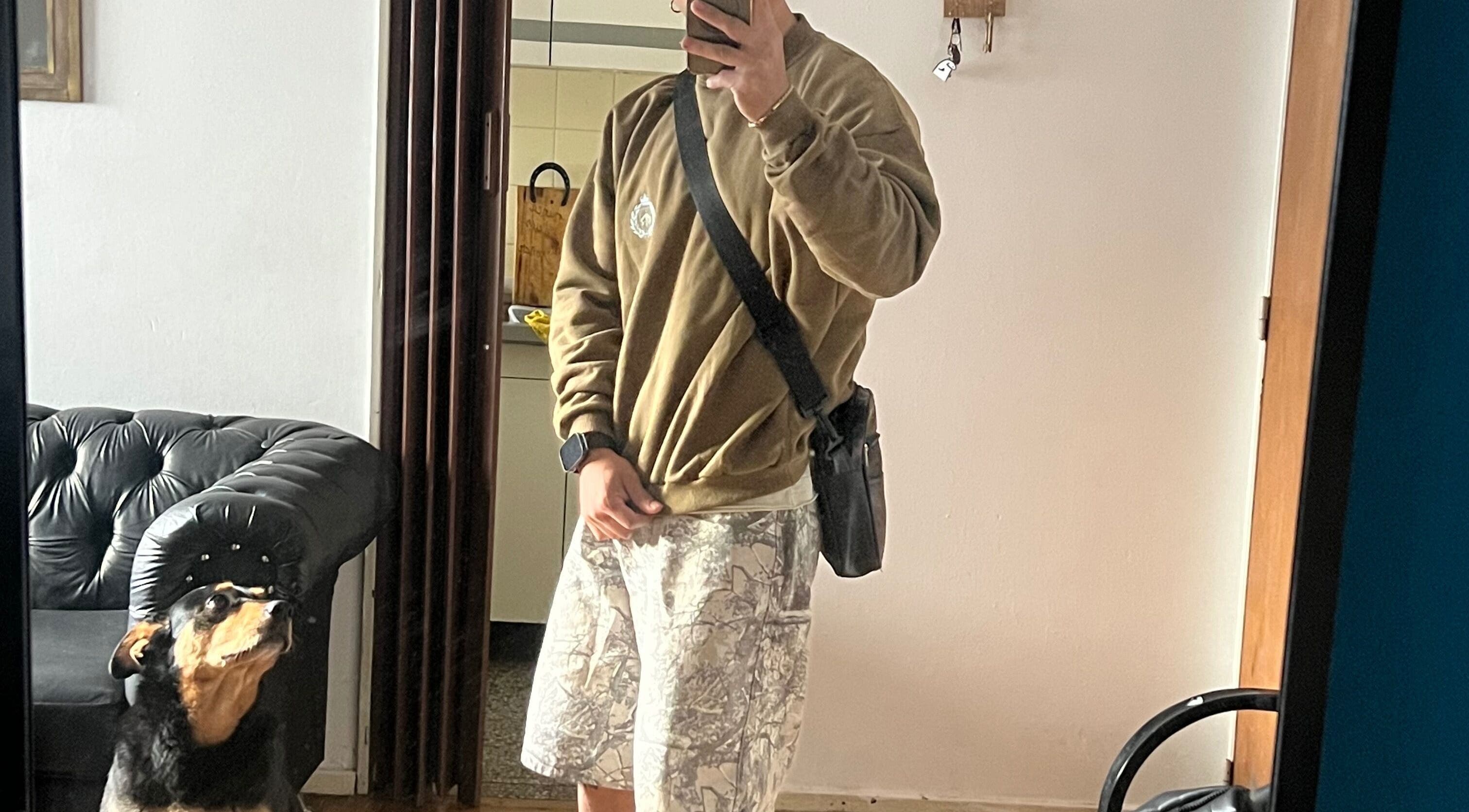 A person in casual attire with a dog in front of a mirror at Lucas Lezcano, Buenos Aires, Ciudad Autónoma De Buenos Aires, AR.