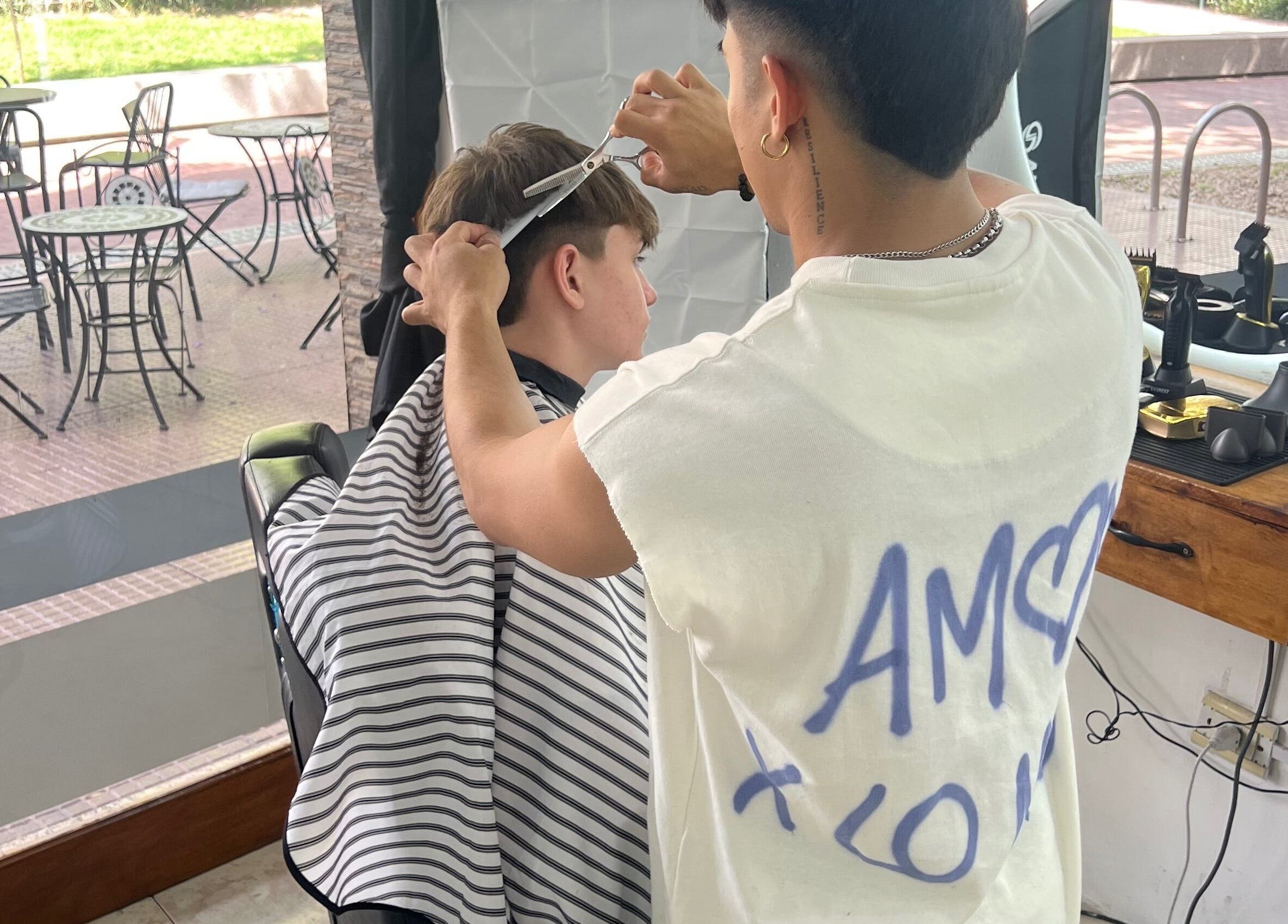 Barber at Lucas Lezcano in Buenos Aires giving a haircut, showcasing the chic salon vibe.