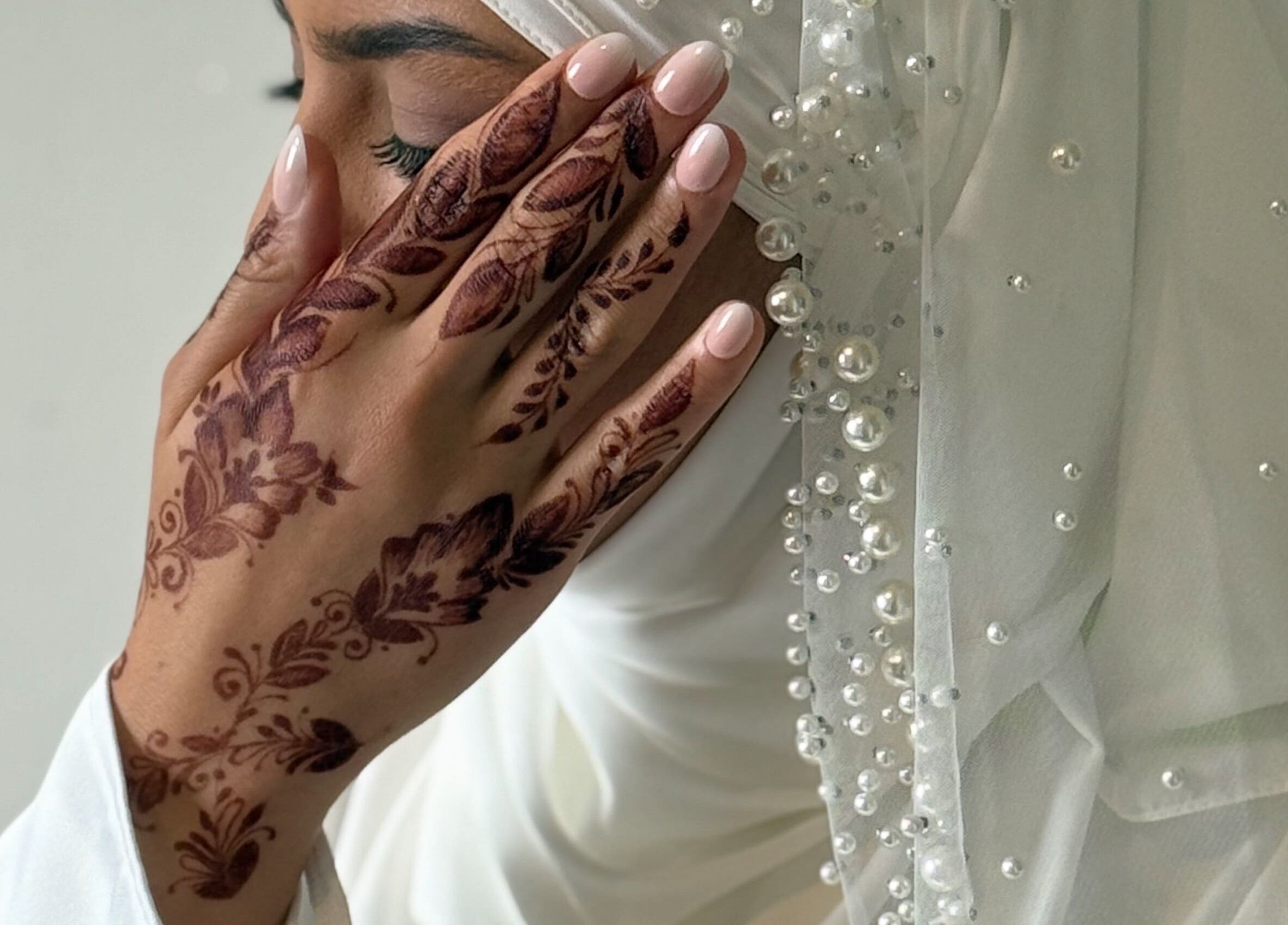 Main avec henné délicat chez HENNA LY69N, Lyon, Auvergne-Rhône-Alpes, FR, parée de perles blanches.