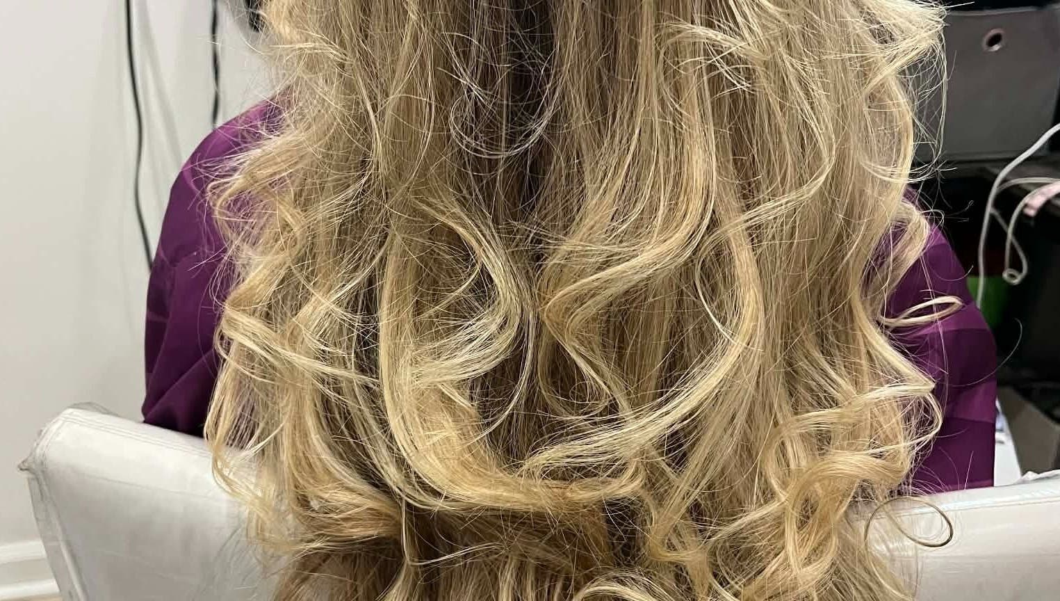 Elegant wavy blonde hairstyle by Hair by Crystal Gayle in Jacksonville, Florida, US.