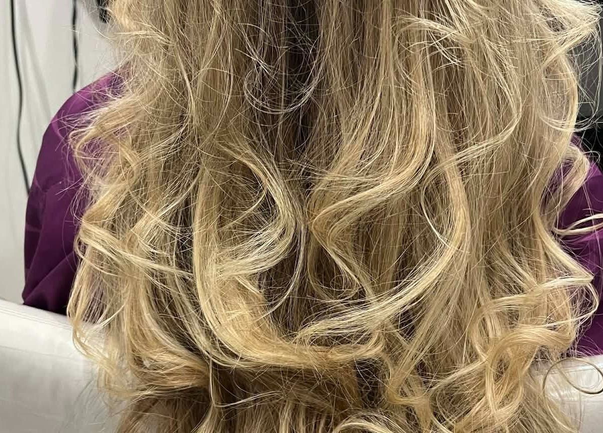 Elegant wavy blonde hairstyle by Hair by Crystal Gayle in Jacksonville, Florida, US.