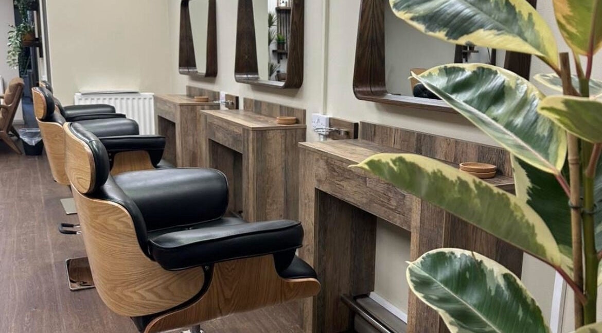 Modern salon chairs and mirrors at Navie Studio, Hull, England, GB. Stylish interior with plant decor.