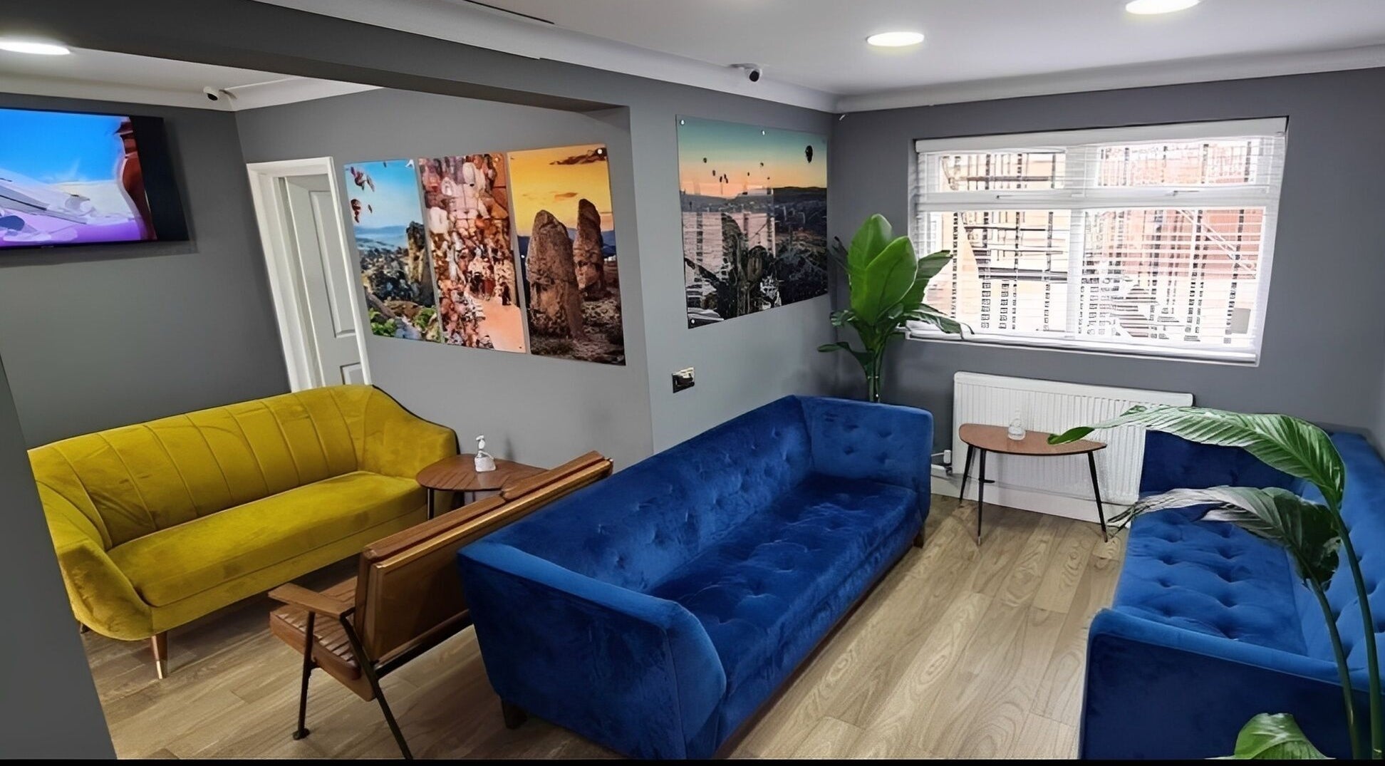 Inviting lounge area at Turkish Barber in Birmingham, England, GB with vibrant sofas and wall art.