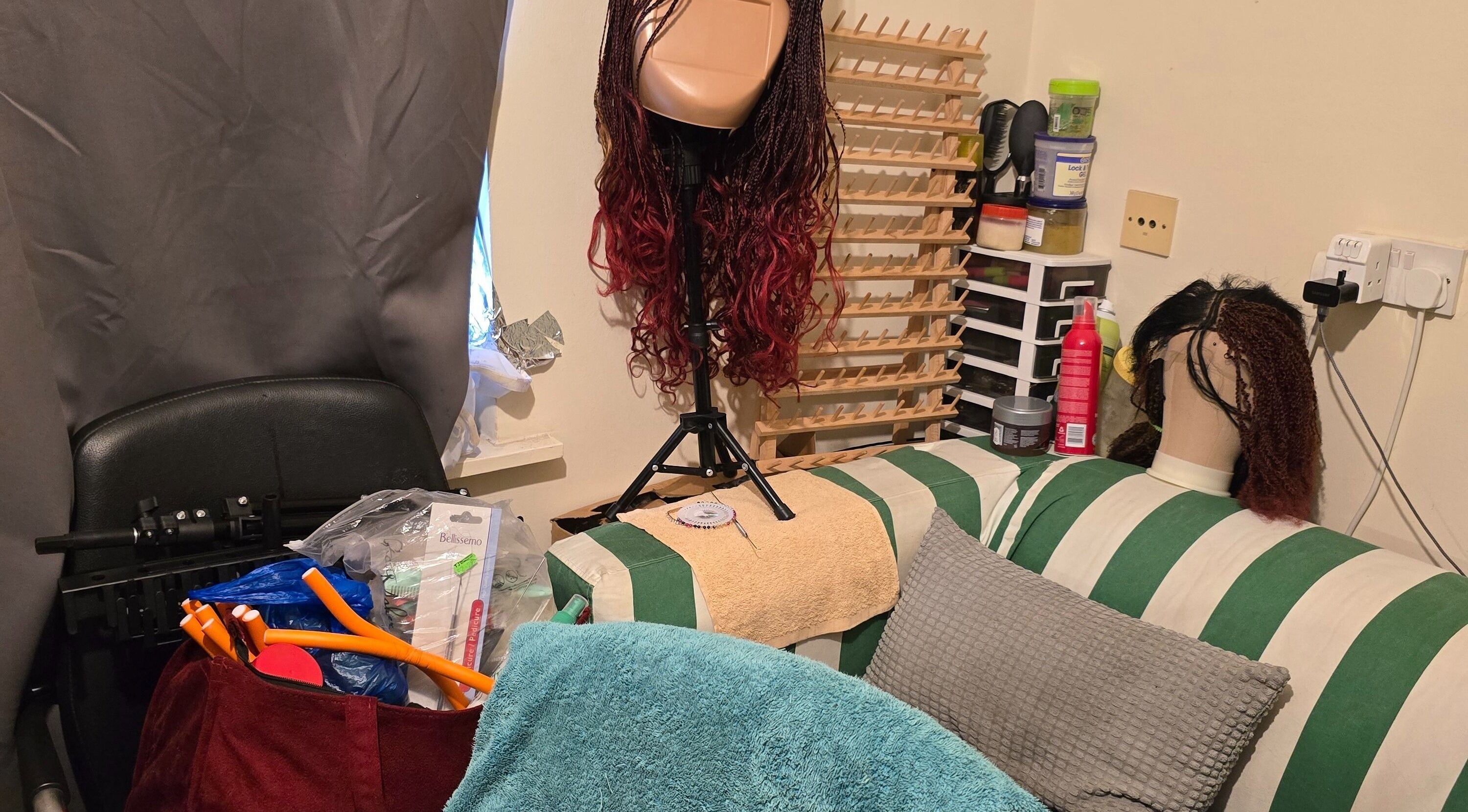 Cozy wig styling setup at Kaffy_houseofbeauty, London, England, GB, featuring styling tools and wigs.
