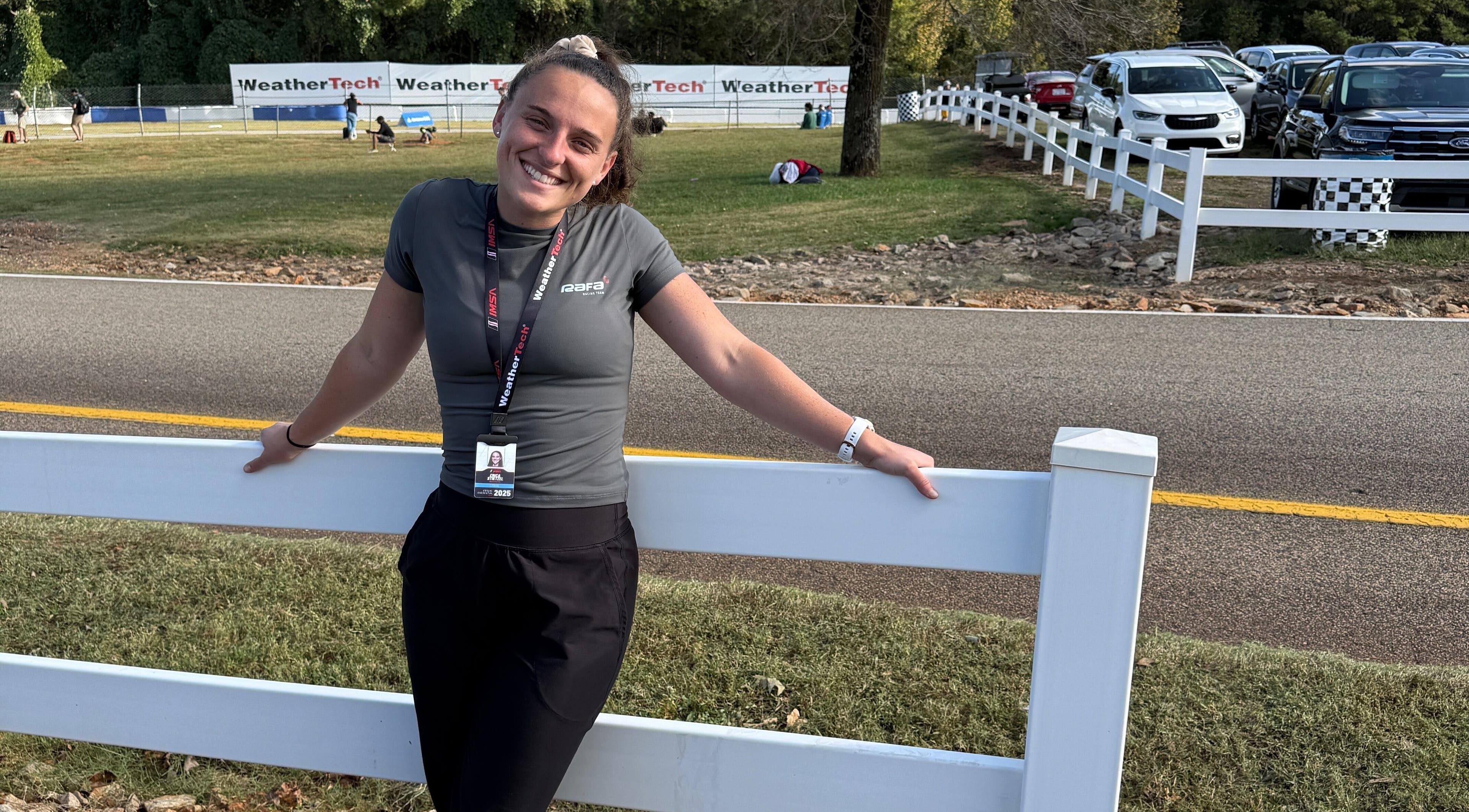 Person smiling near a white fence at Strides Performance, Stamford, Connecticut, US.