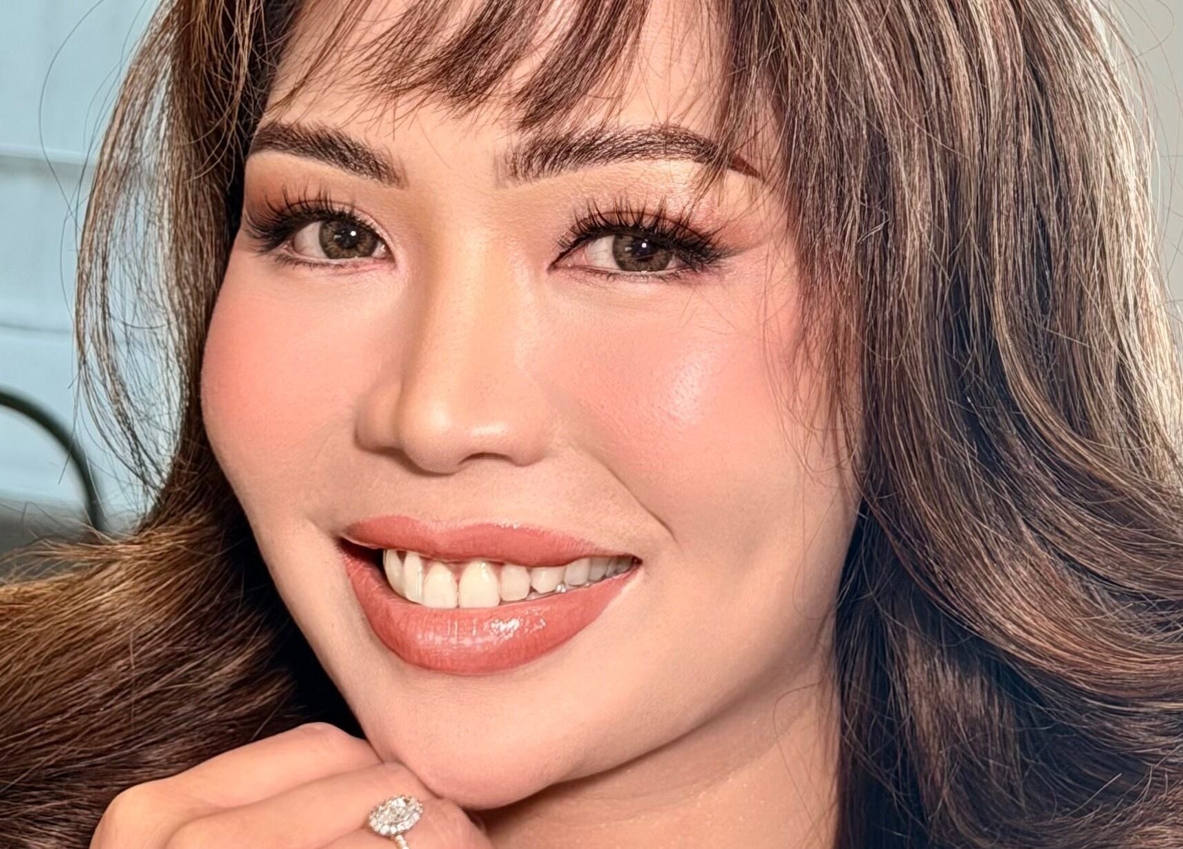 A smiling client with stylish hair and makeup by Sy Bhern Montomo Makeup and Hair Artist in Melbourne, Victoria, AU.