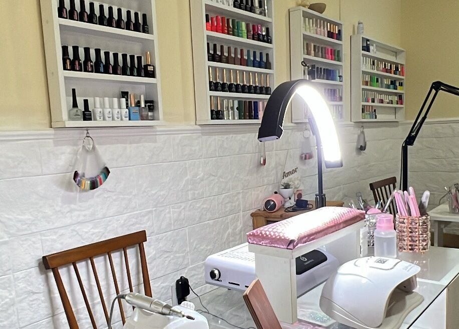 Mesa de manicura en Nails by Guada, Villa Vatteone, Provincia De Buenos Aires, AR, con estantes llenos de esmaltes.