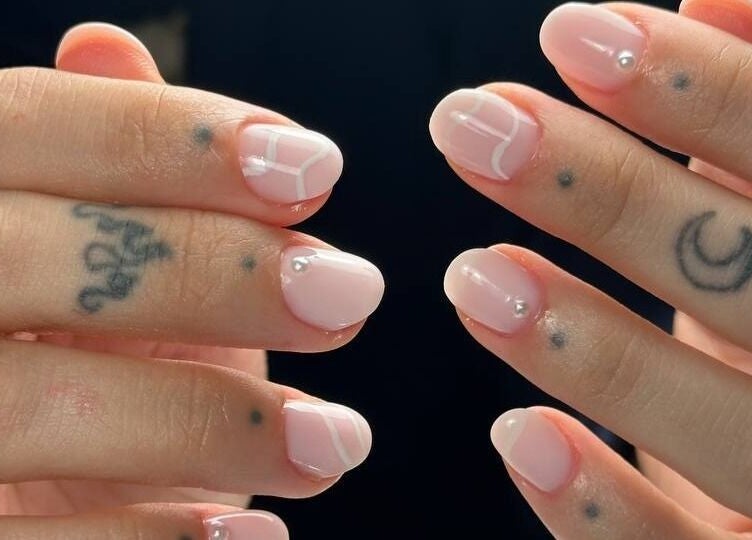Stylish pink nail design with tattoos at DZVINKA Beauty Studio, Edmonton, Alberta, CA.