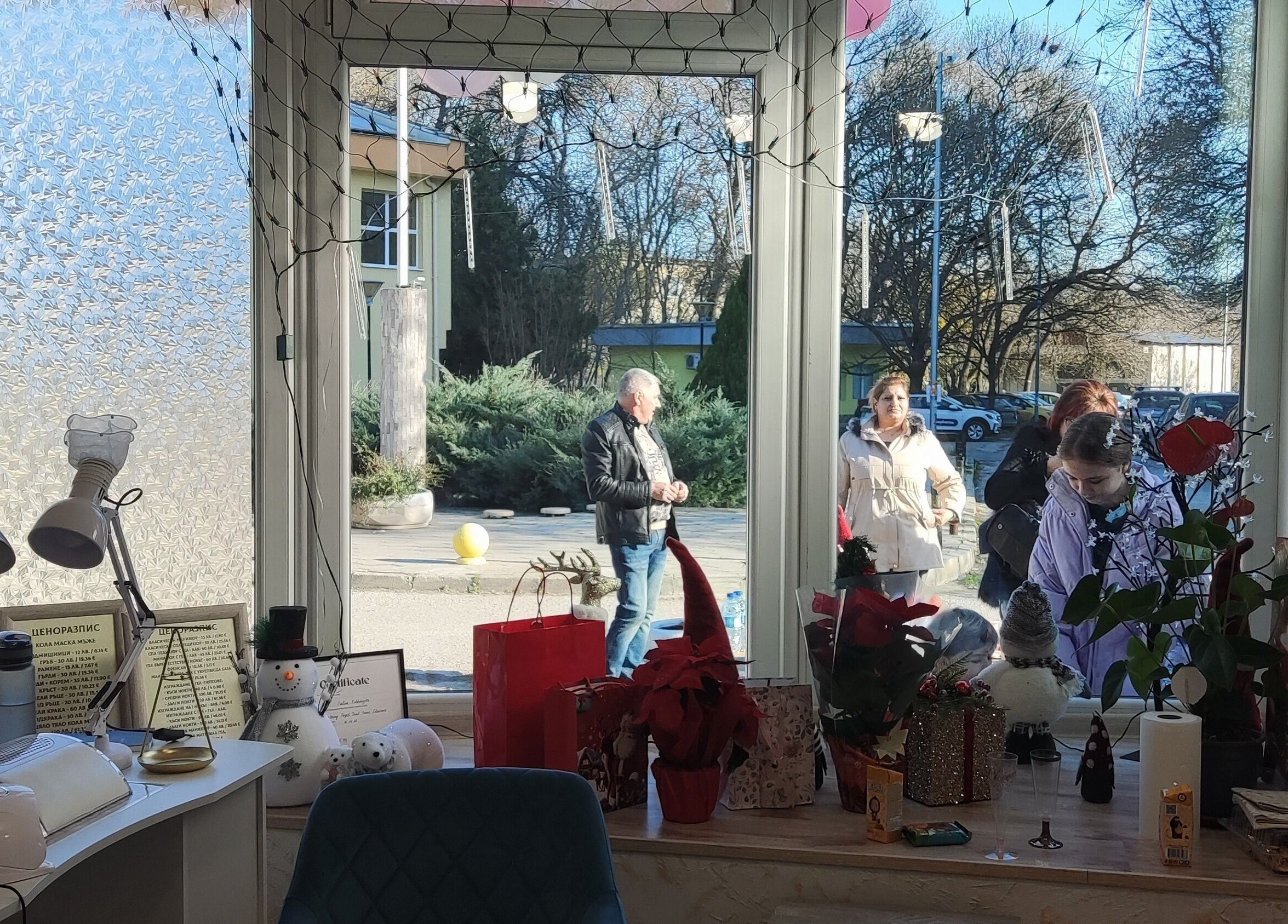 Декорирана витрина на Ina Beauty Studio, Пловдив, Пловдив, BG, отразяваща спокойна улична сцена.