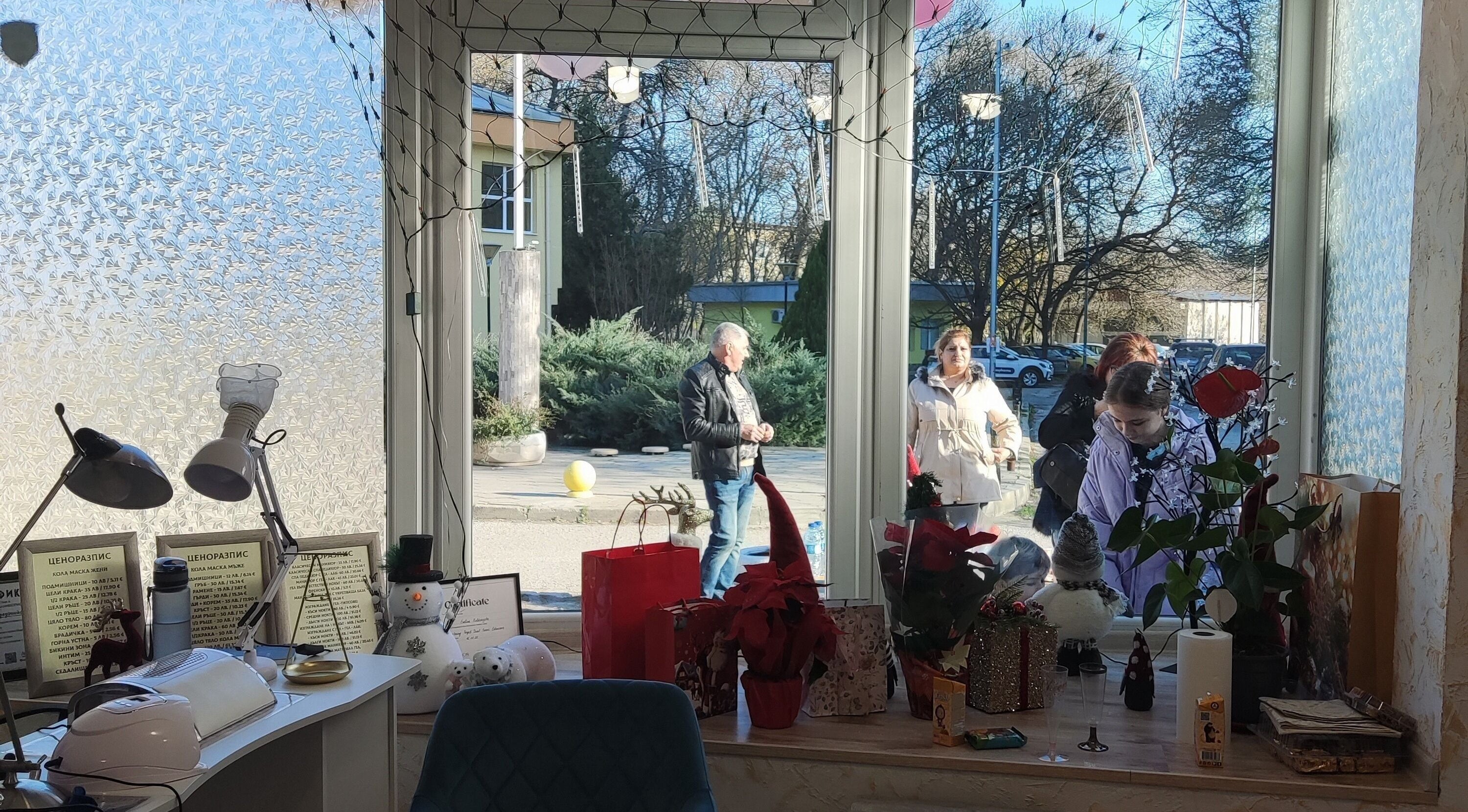 Декорирана витрина на Ina Beauty Studio, Пловдив, Пловдив, BG, отразяваща спокойна улична сцена.