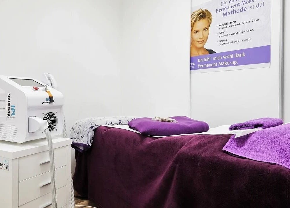 Moderner Wellnessraum bei Beauty4Life, München, Bayern, DE mit Stil. Purpurfarbene Details und IPL-Gerät.