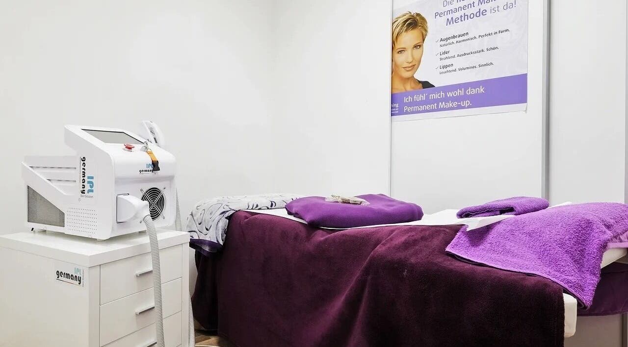 Moderner Wellnessraum bei Beauty4Life, München, Bayern, DE mit Stil. Purpurfarbene Details und IPL-Gerät.