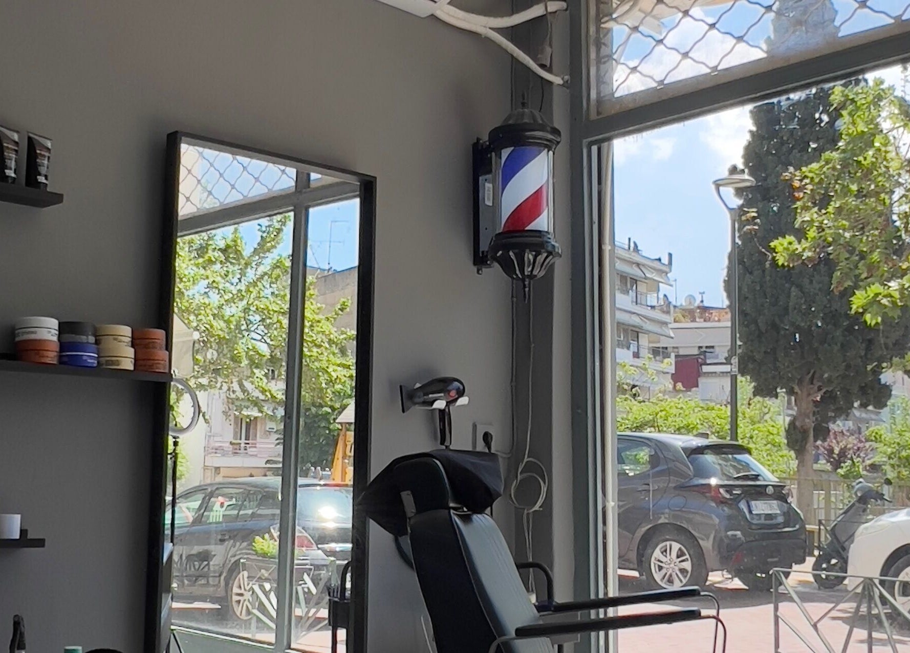 Interior of NALDO HAIR STUDIO in Neapoli, GR showcasing modern salon chair and hair products.