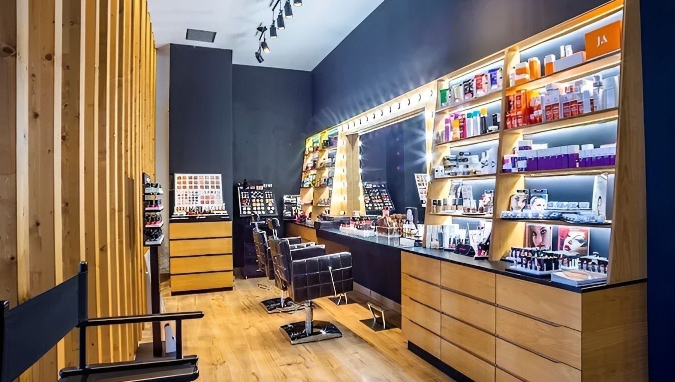 Κομψός χώρος ομορφιάς στο MrandMrsspa, Chalkida, GR με καρέκλες και προϊόντα μακιγιάζ σε ξύλινα ράφια.