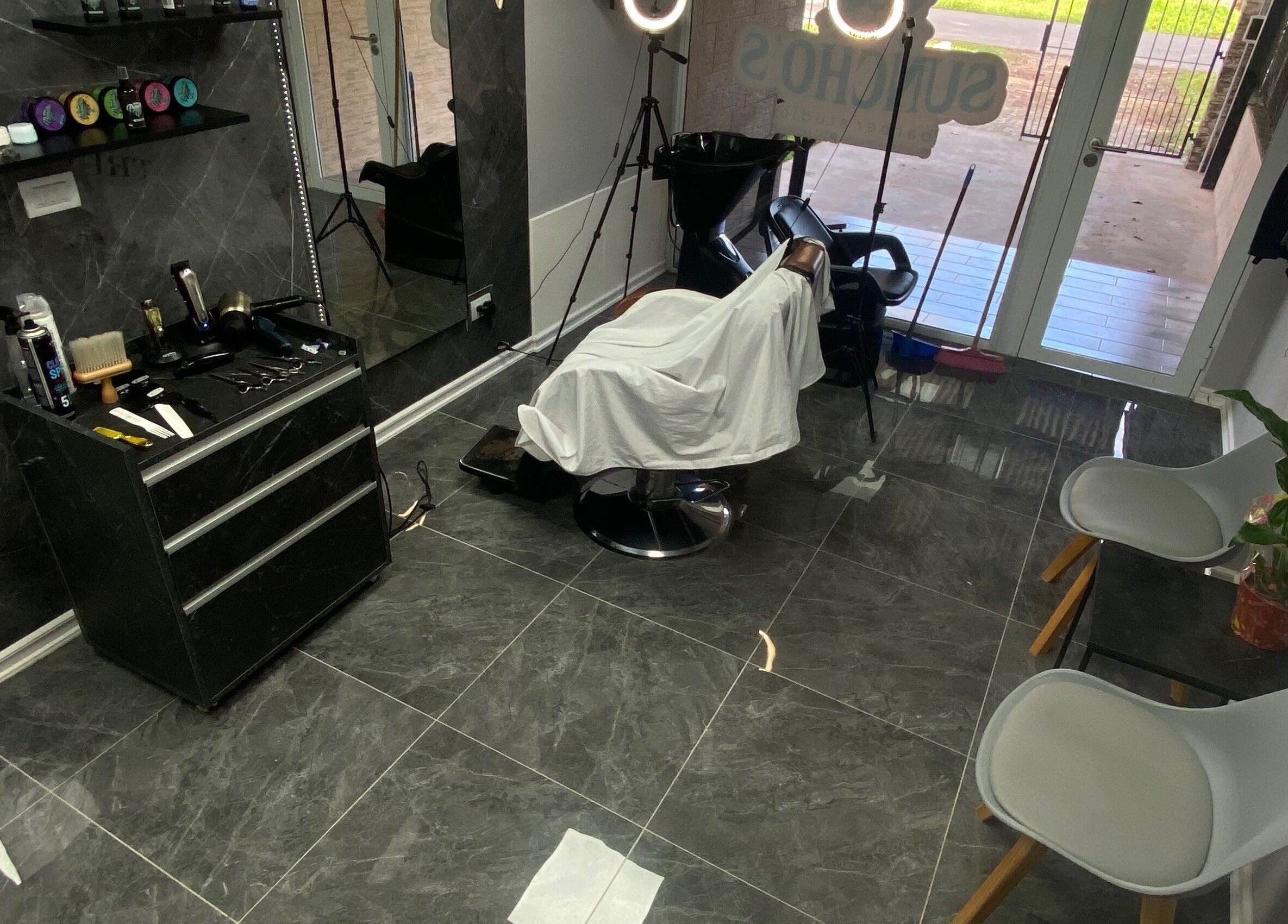 Interior elegante de Sunchos Barber Studio en Funes, Santa Fe, AR, mostrando sillas y herramientas de barbería.